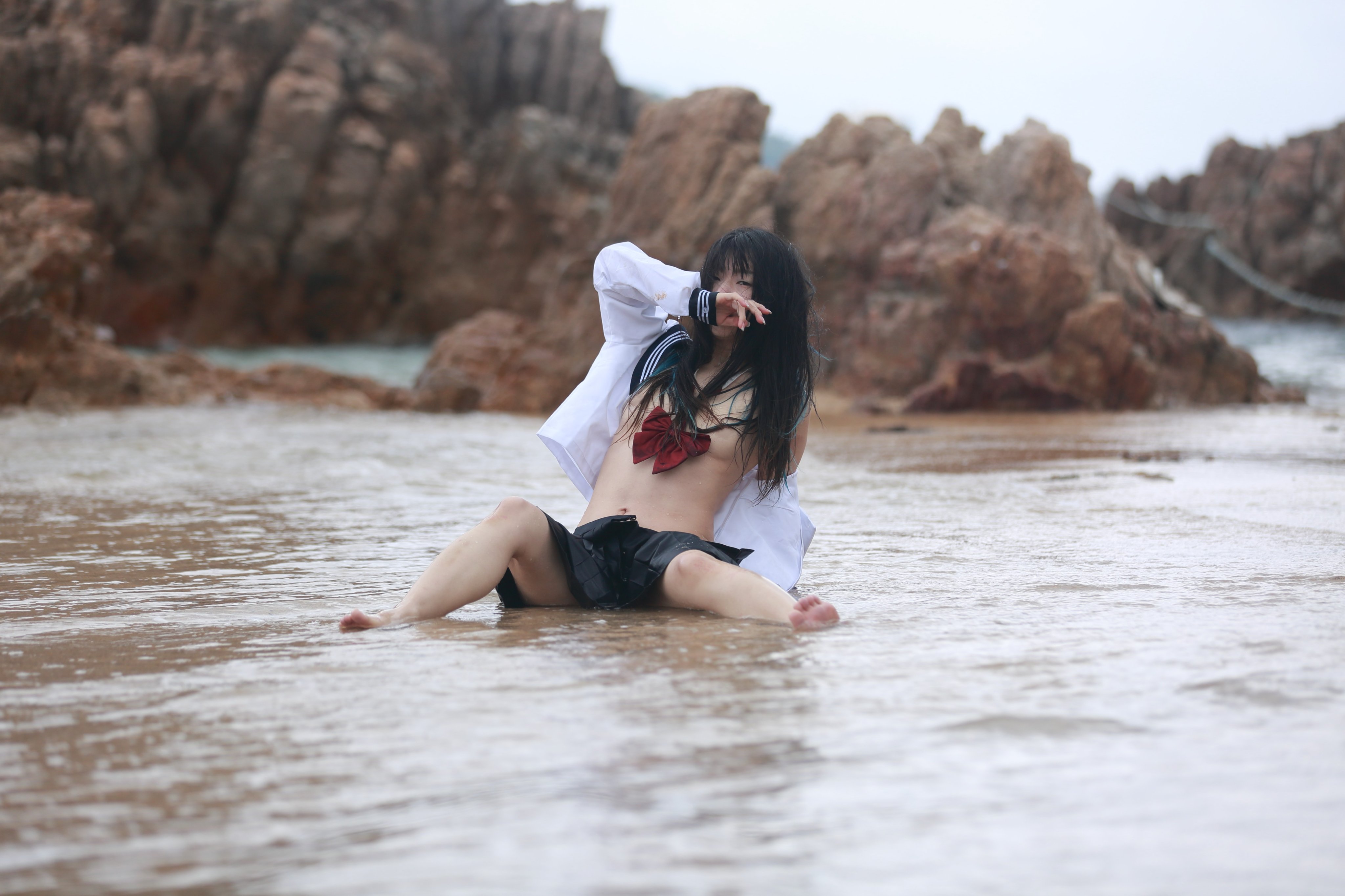 穿着白色衬衫和黑色衬衫的女人坐在水里。