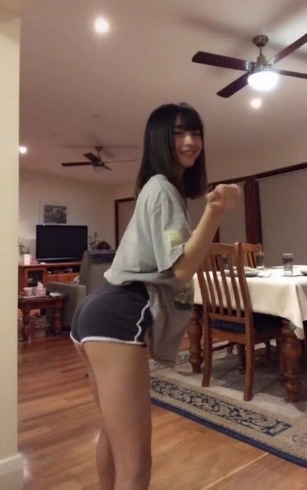 穿着灰色衬衫和短裤的女人正在玩一个视频游戏。