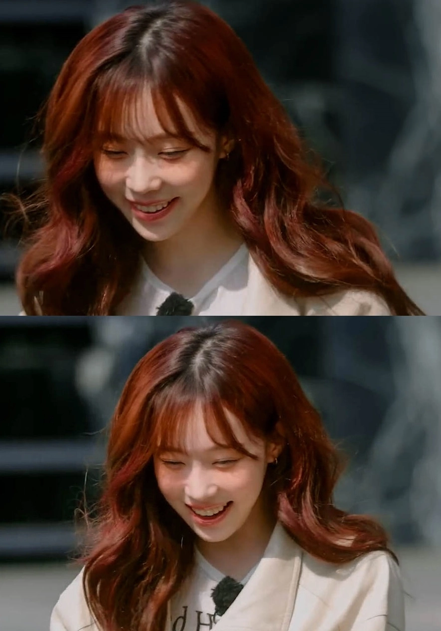 红头发的女人在相机前微笑。