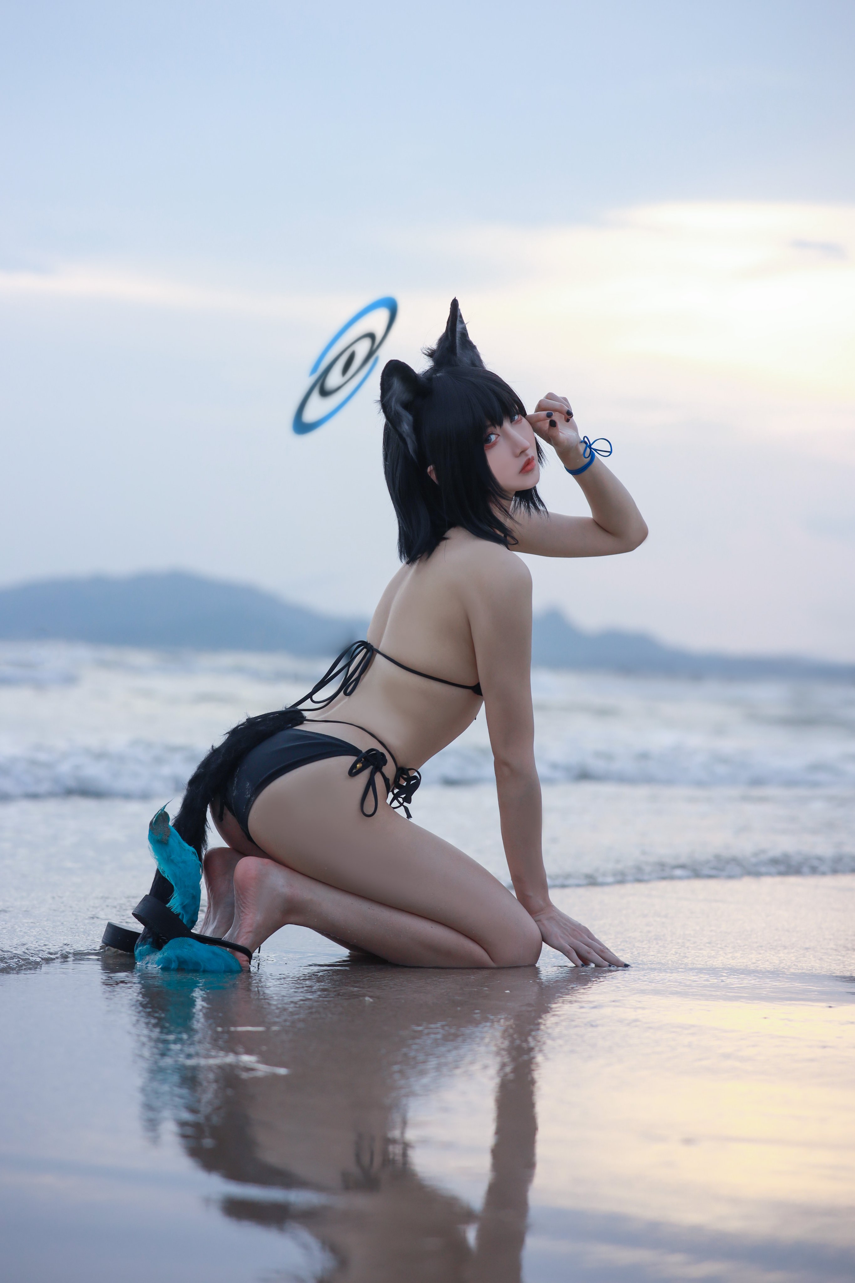 穿着比基尼的女人,一只猫尾巴和一个蓝色弗里斯比。