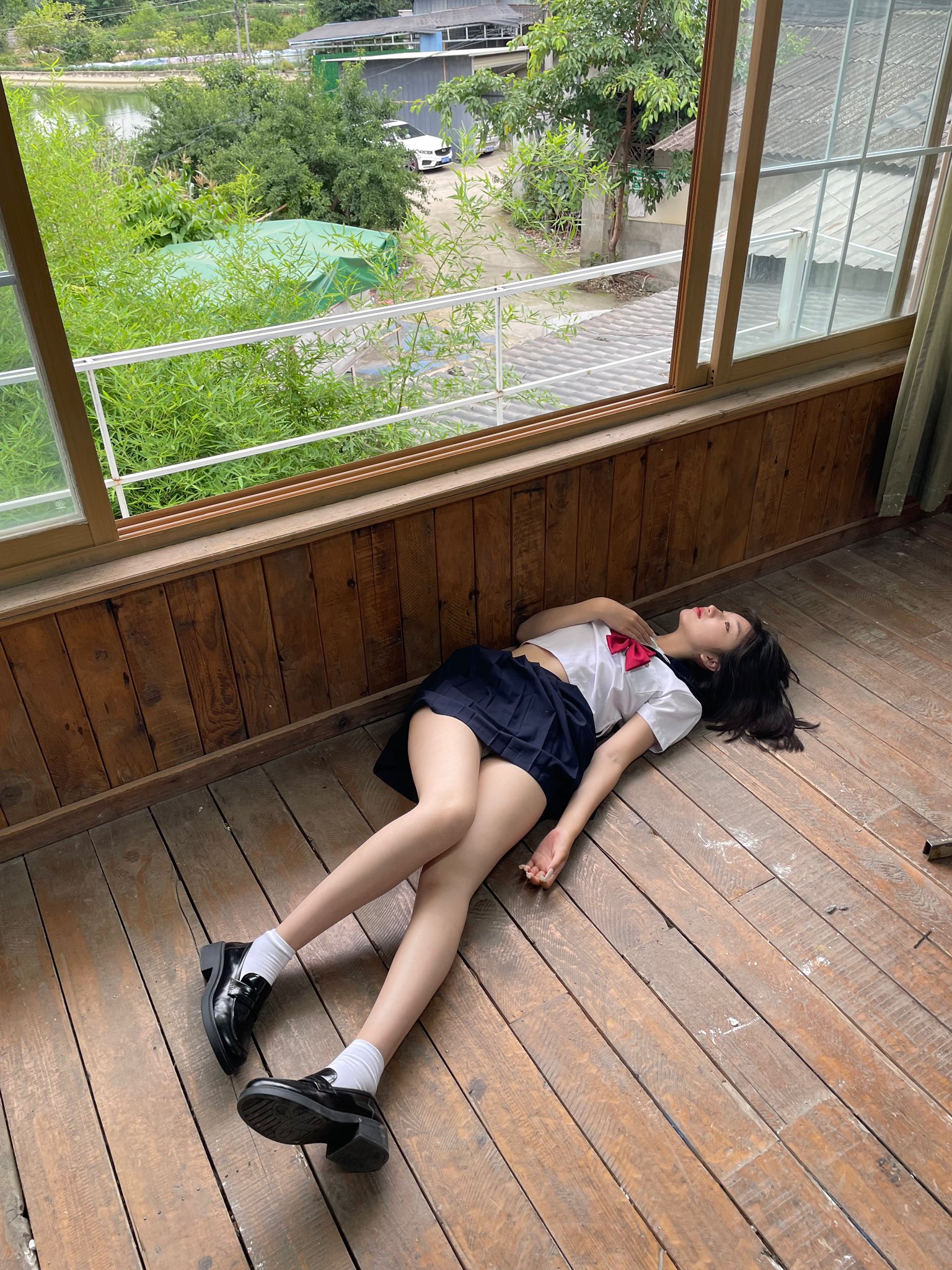 穿着学校制服的女孩躺在地板上。