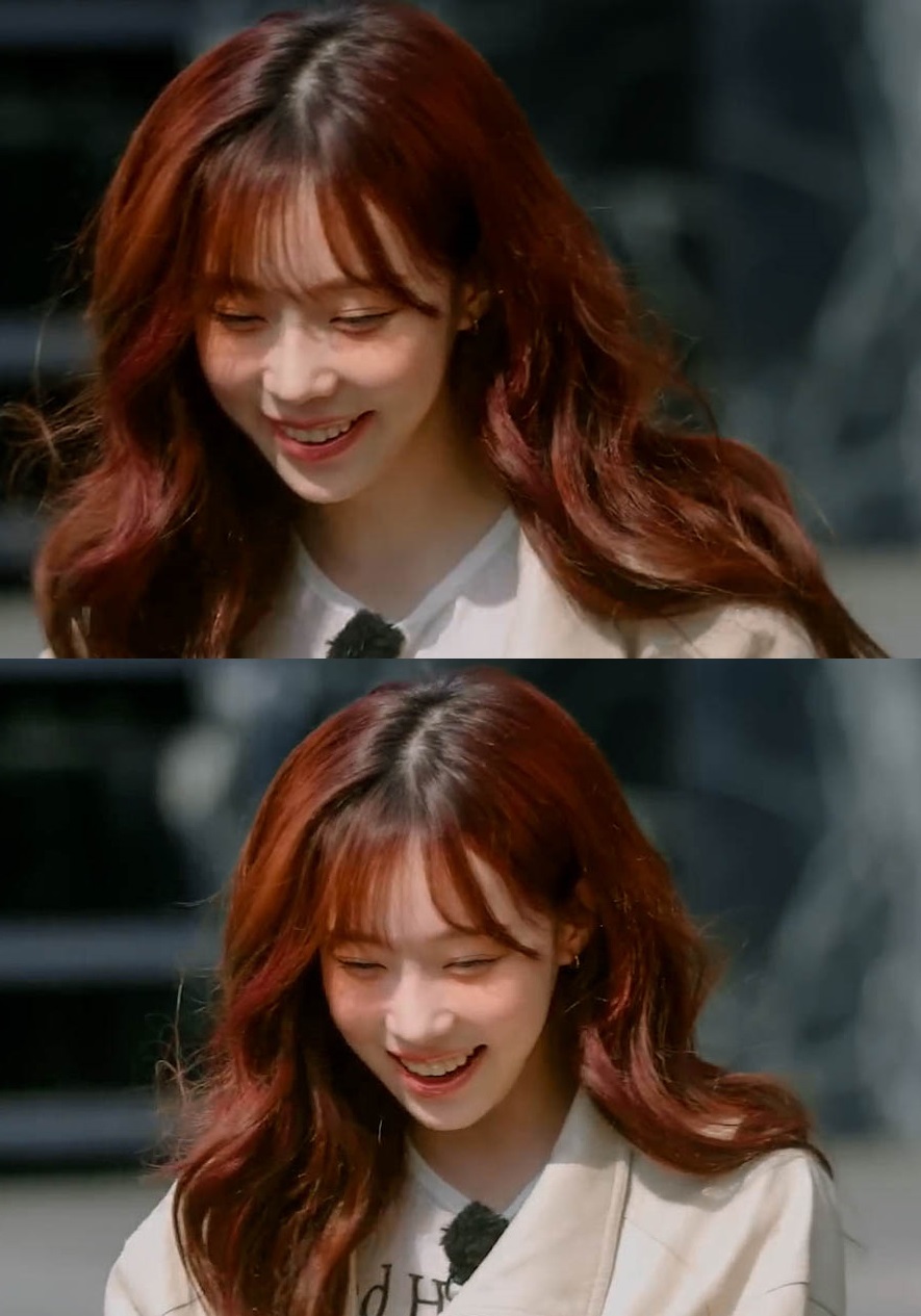 红头发的女人在相机前微笑。