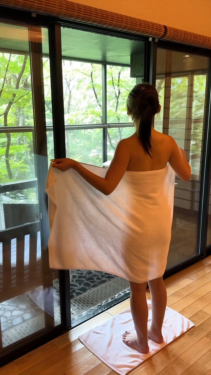 女人在浴室里拿着一个毛巾。