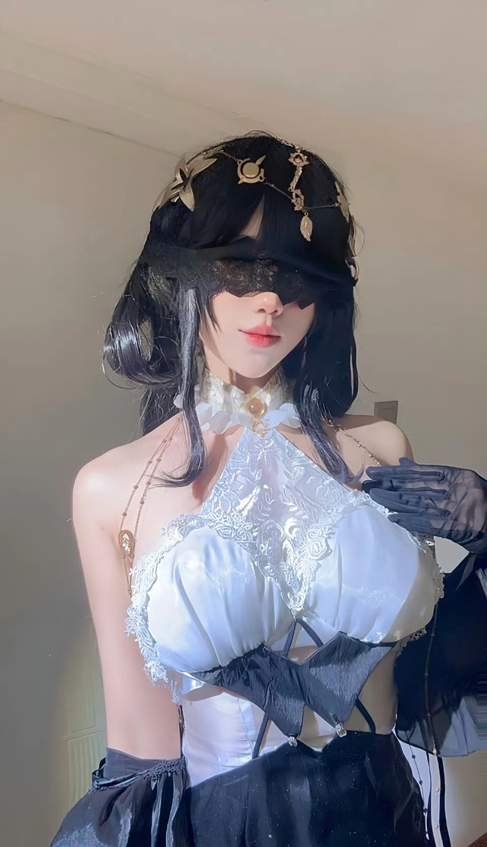 女人穿着一个白色的绳索顶部和黑色的手套。