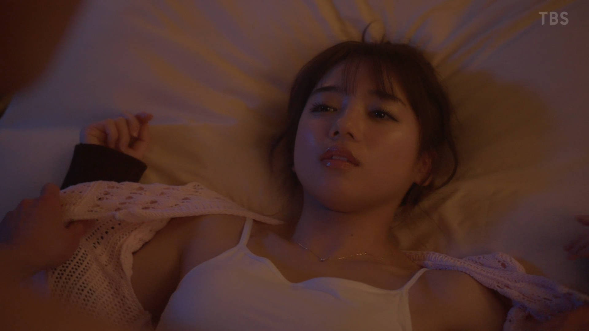 女人躺在床上,穿着一件白色衬衫。