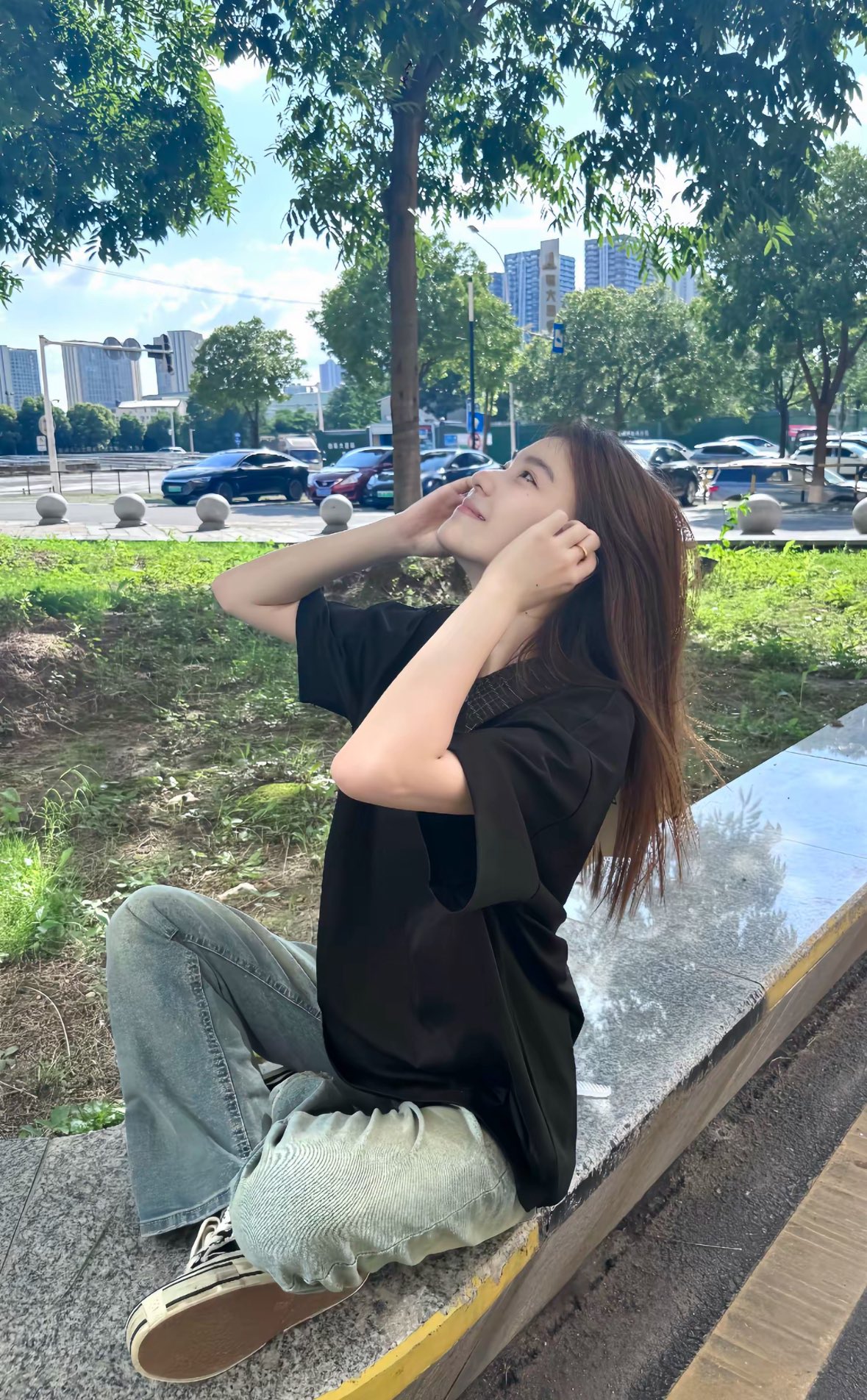 穿着黑色衬衫的女人坐在一个凳子上。