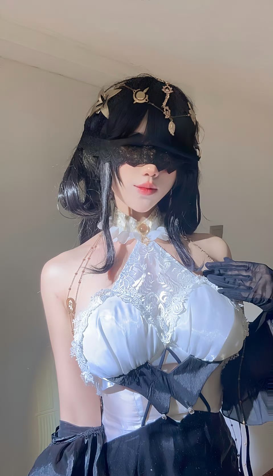 女人穿着一个白色的绳索顶部和黑色的手套。