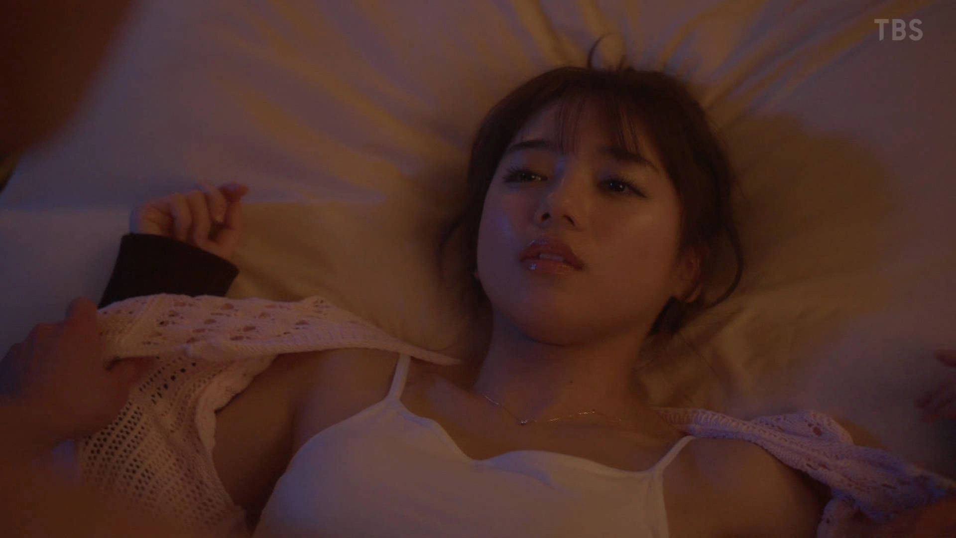 女人躺在床上,穿着一件白色衬衫。