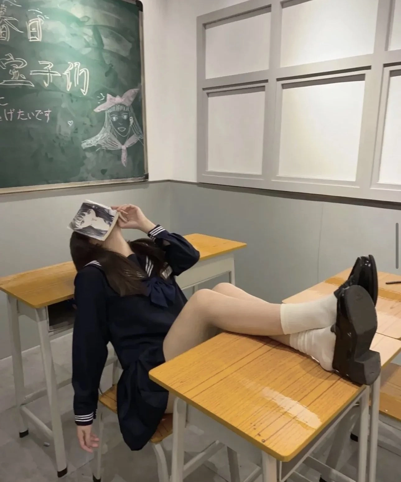 女孩在坐在桌子上读一本书。