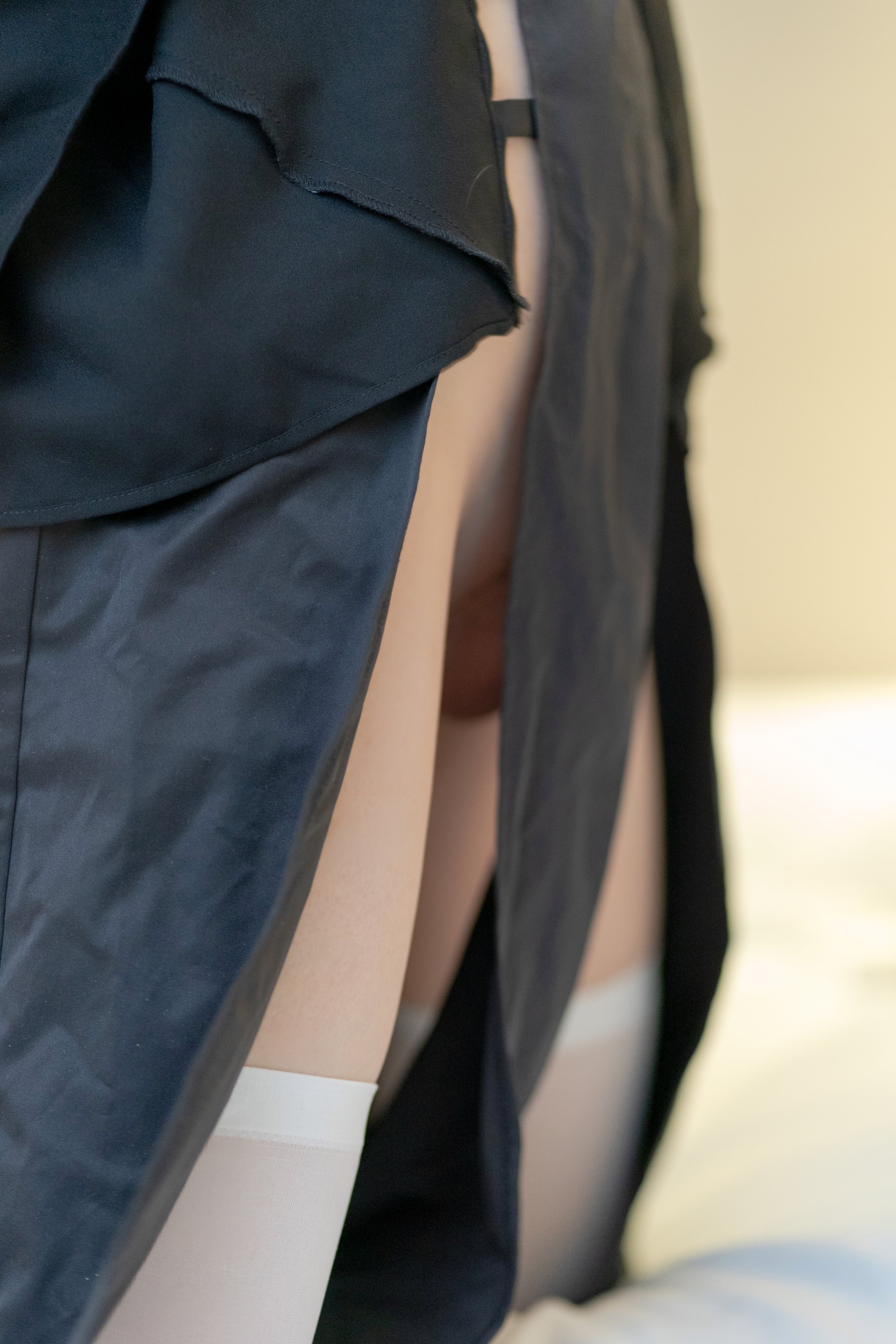 女人穿着一件黑色的裙子,一件白色的裤子和黑色的袜子。