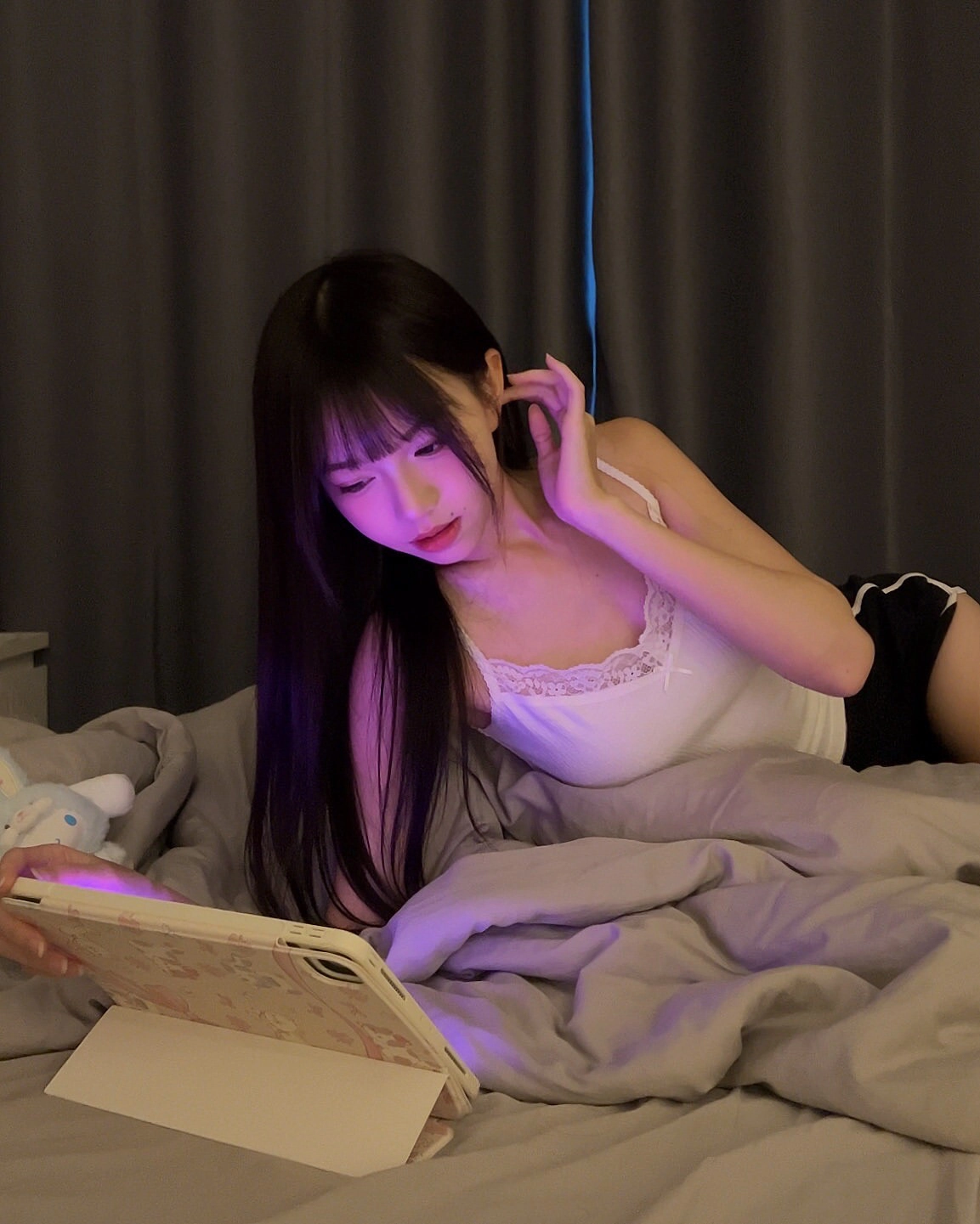 长头发的女人躺在床上,看着手机。