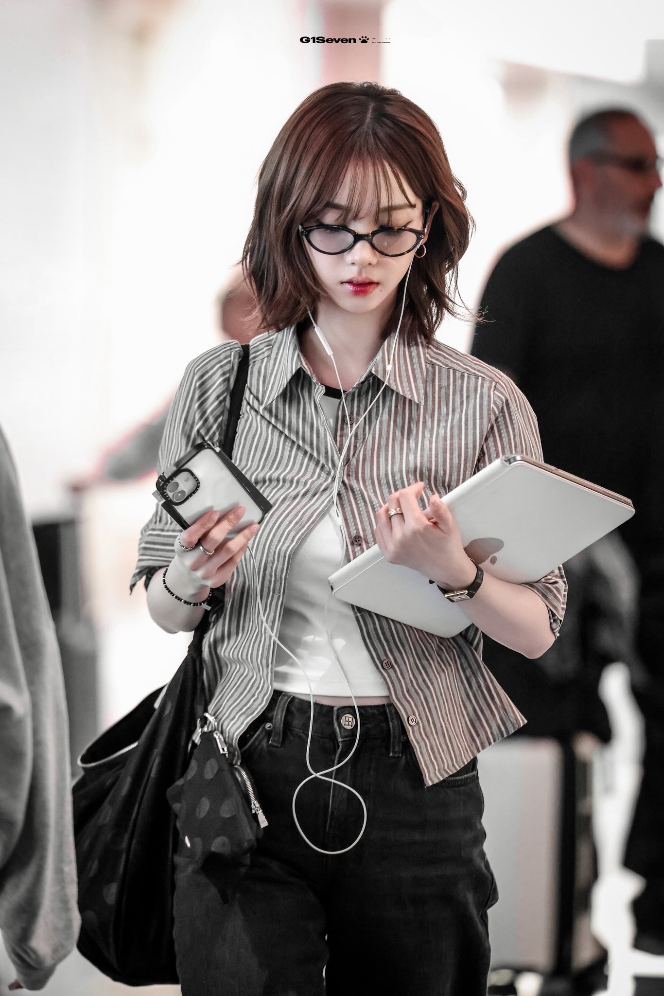 一位戴着眼镜和一件白色衬衫的女人拿着一颗药丸。