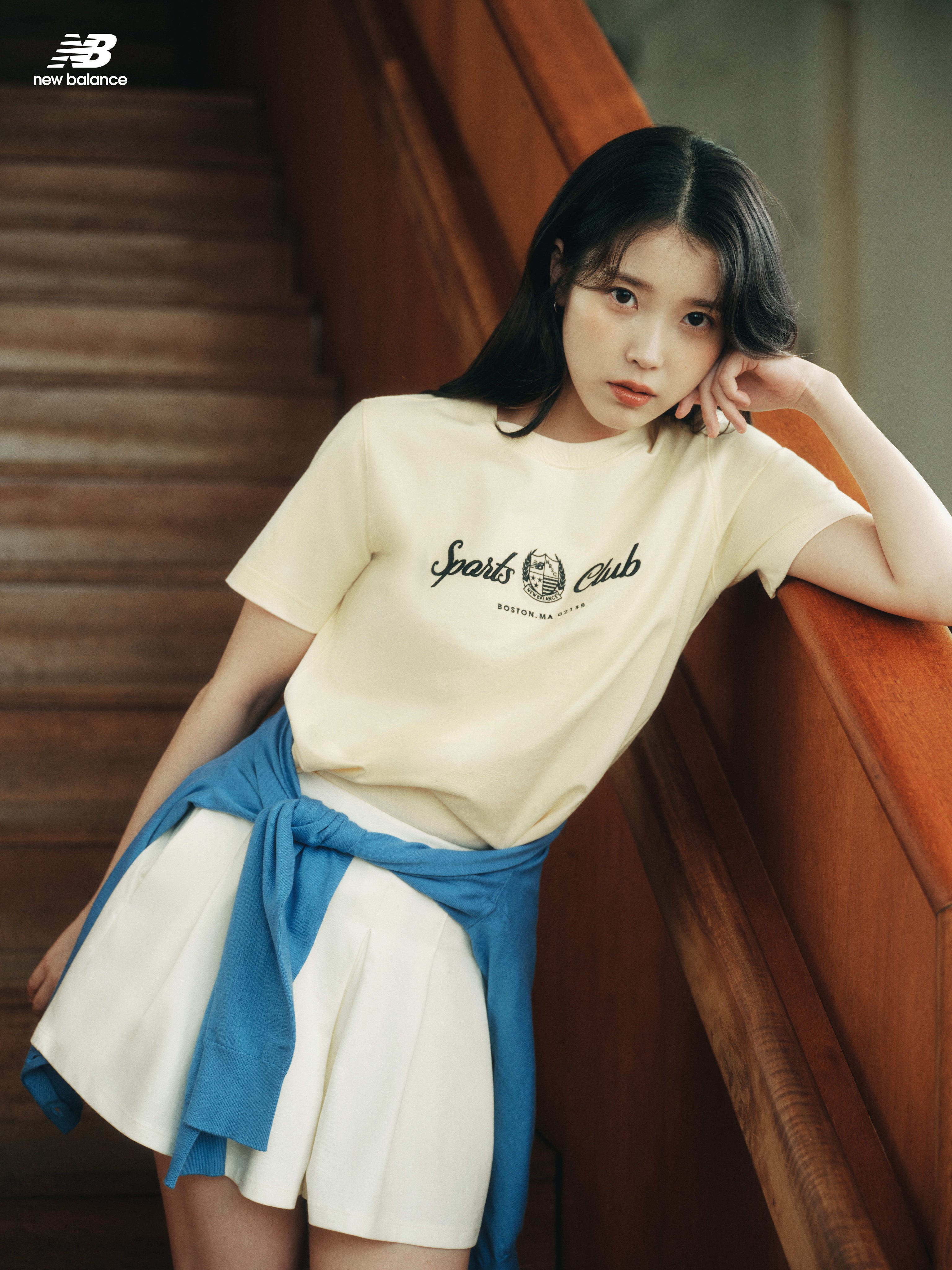 女人穿着一件黄色衬衫,上面有体育俱乐部标志。