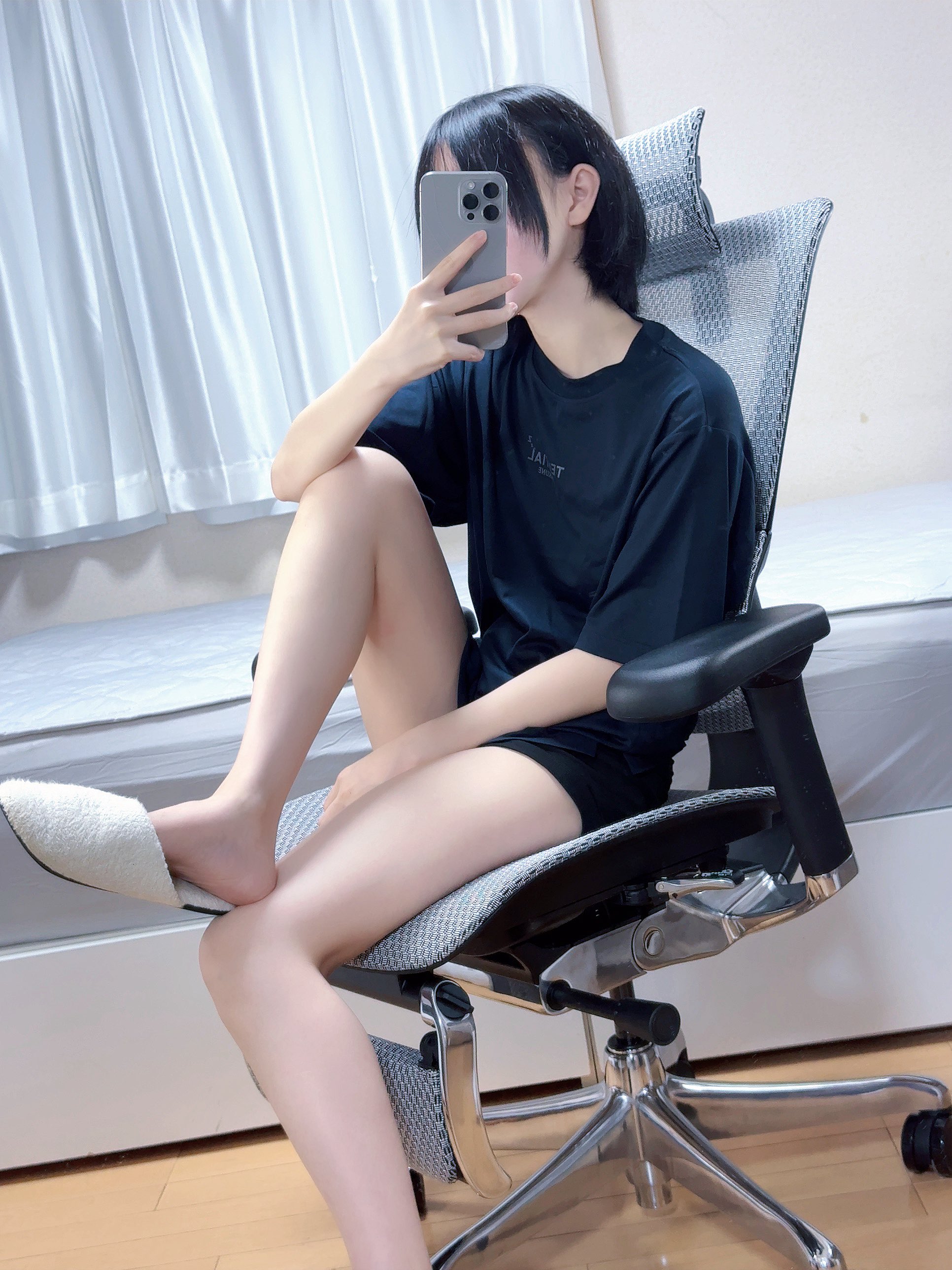 女人坐在椅子上,拿着手机。