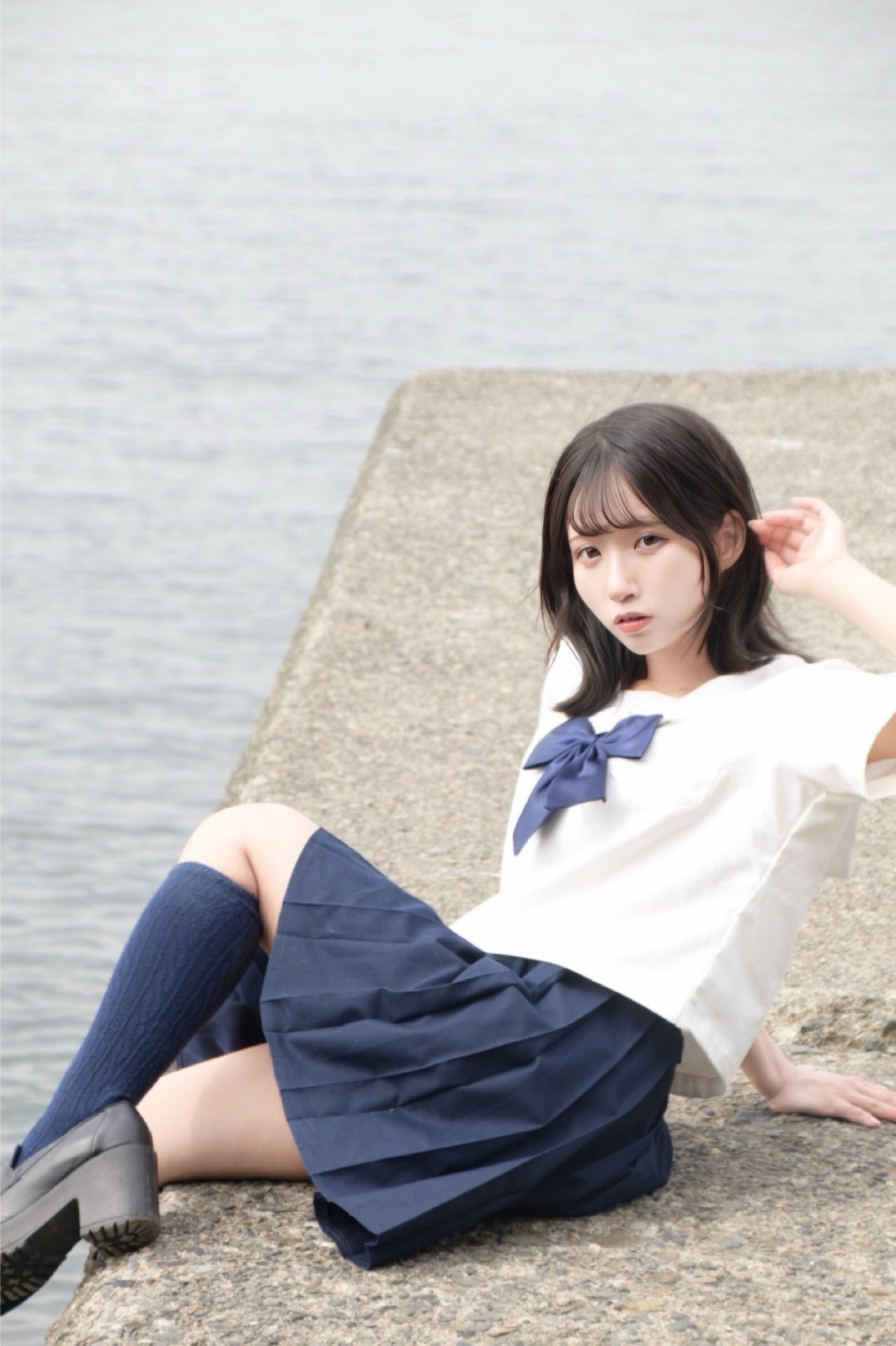 一位穿着白色衬衫和黑色衬衫的女人带着蓝色袋子在空中跳跃。