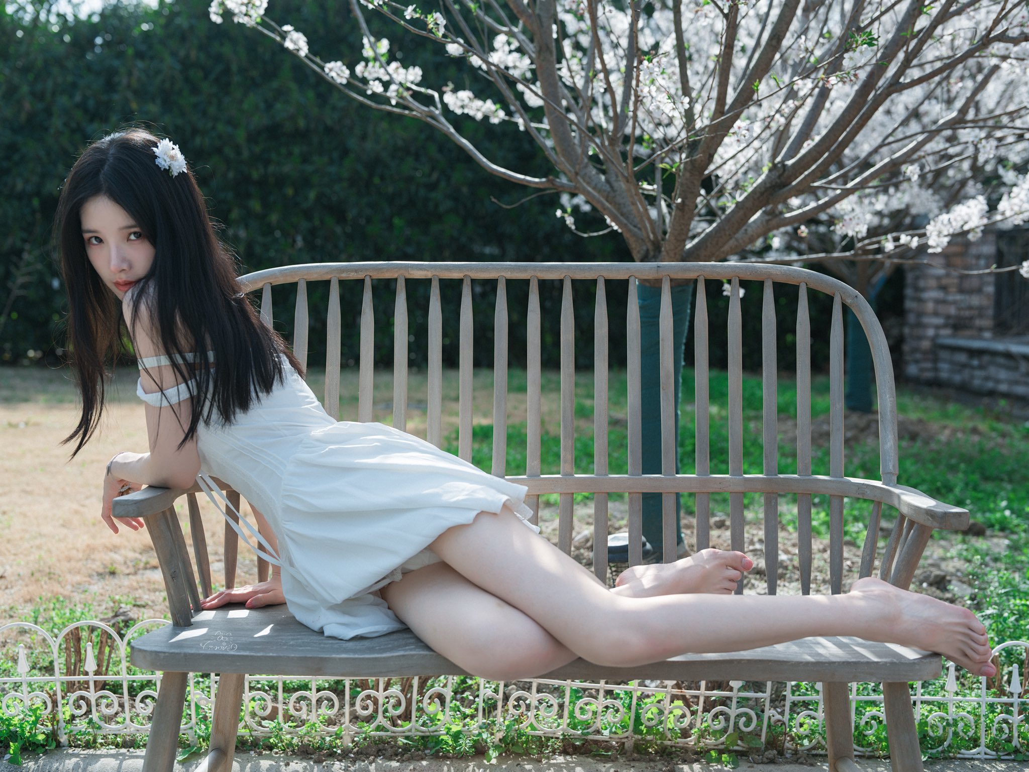 女人坐在一个凳子上,她的腿交叉。