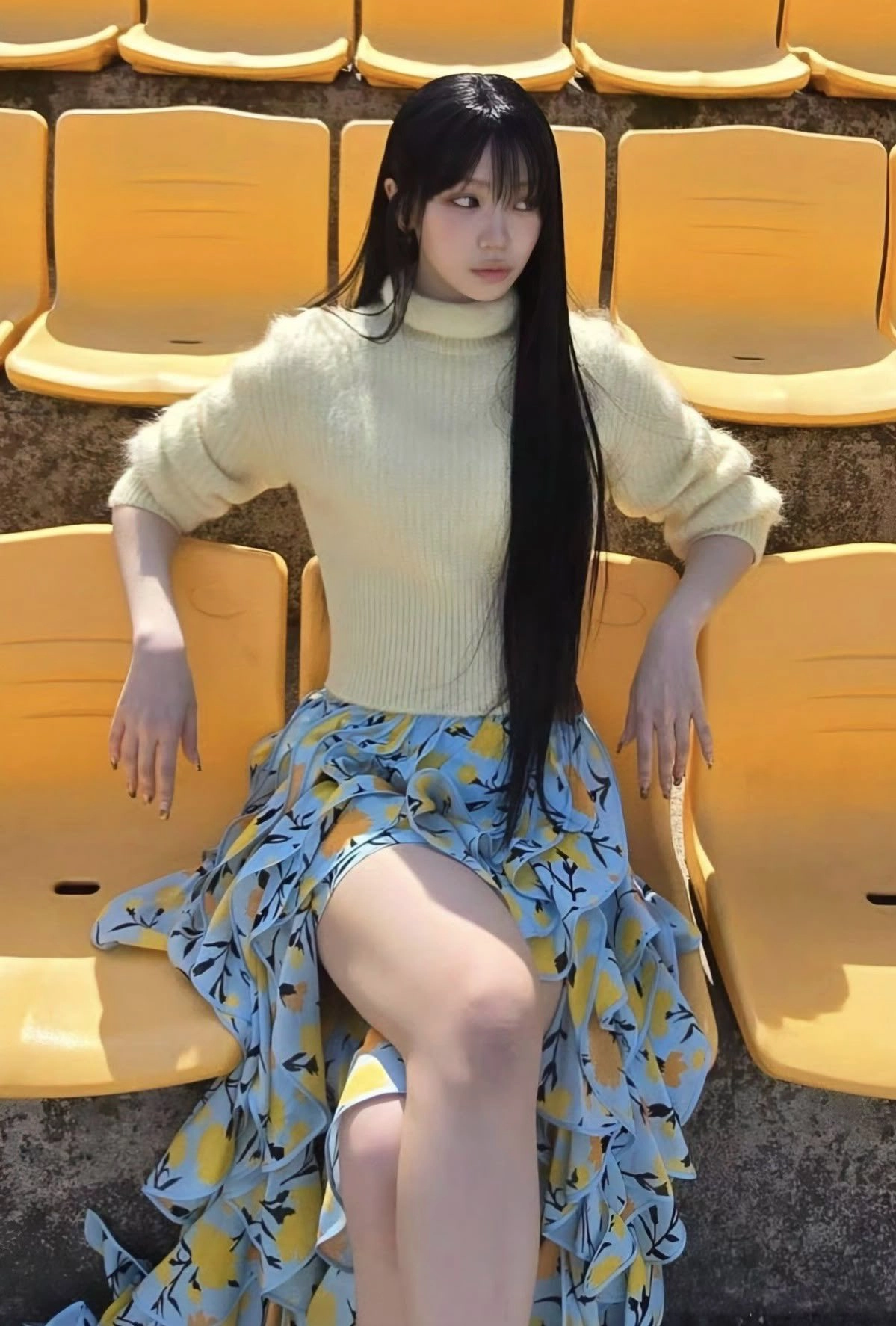 长头发和黄色衬衫的女人坐在一个黄色的椅子上。