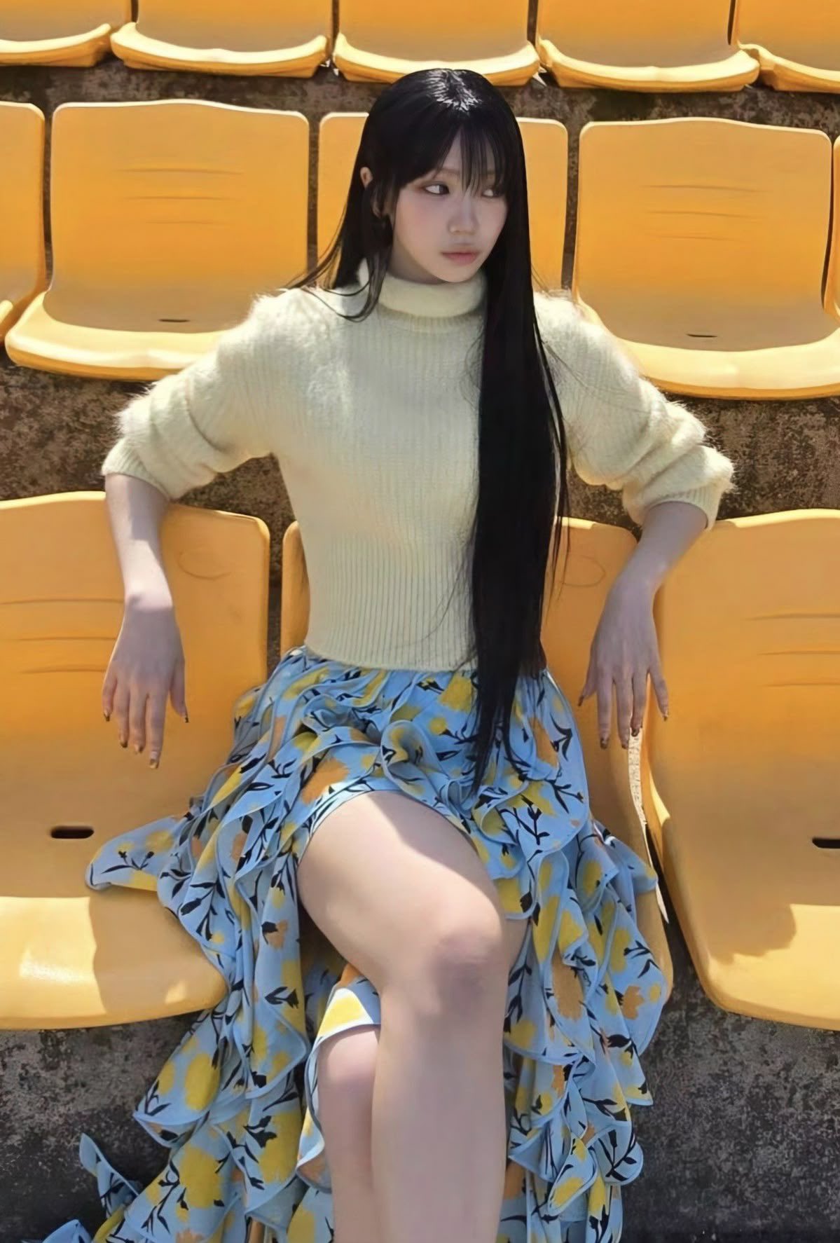 长头发和黄色衬衫的女人坐在一个黄色的椅子上。