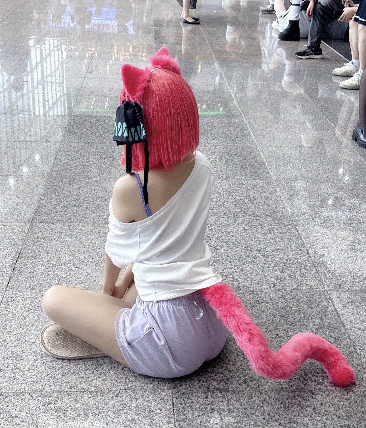 红发和猫尾巴的女人坐在地板上。