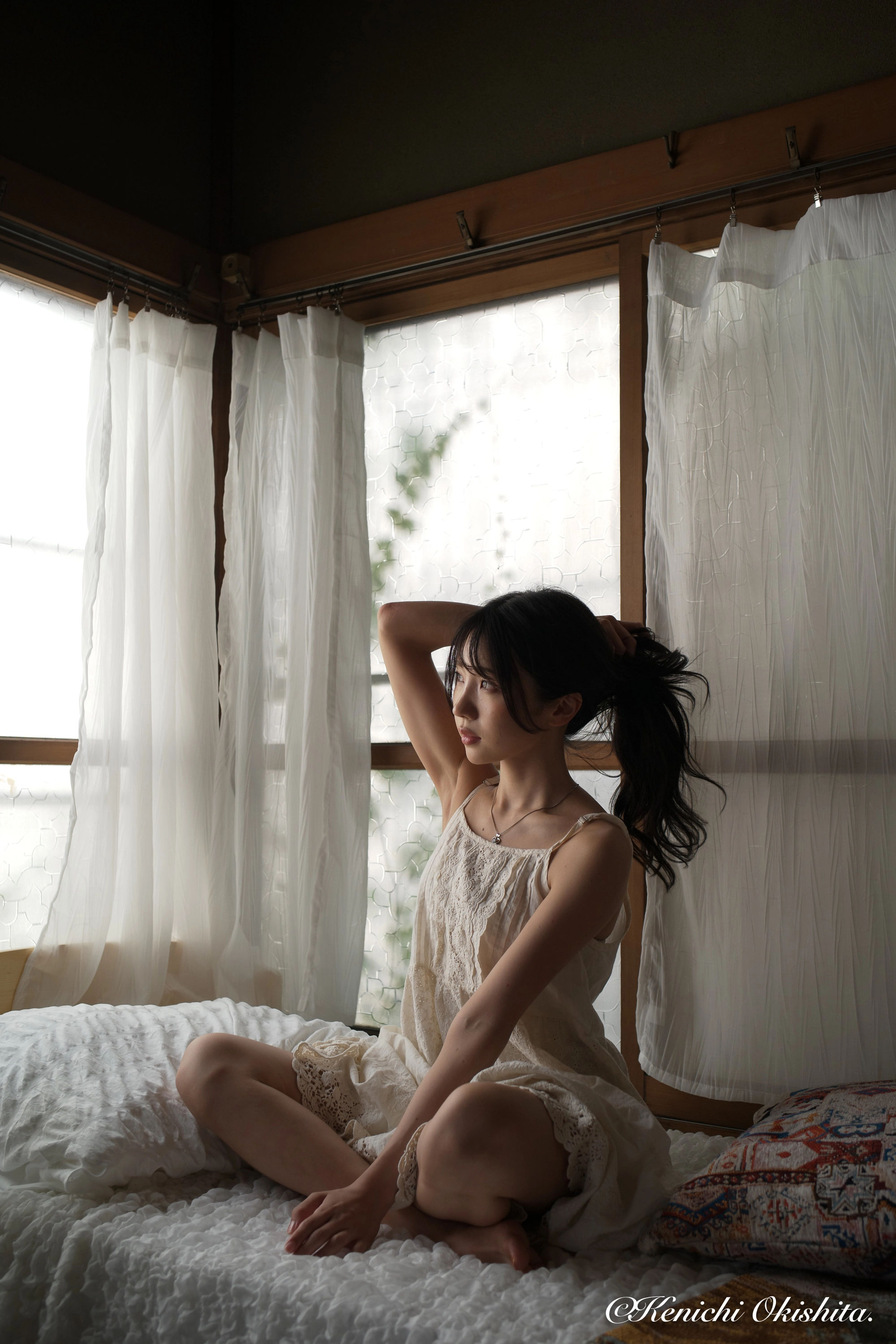 穿着白色衣服的女人坐在床上。