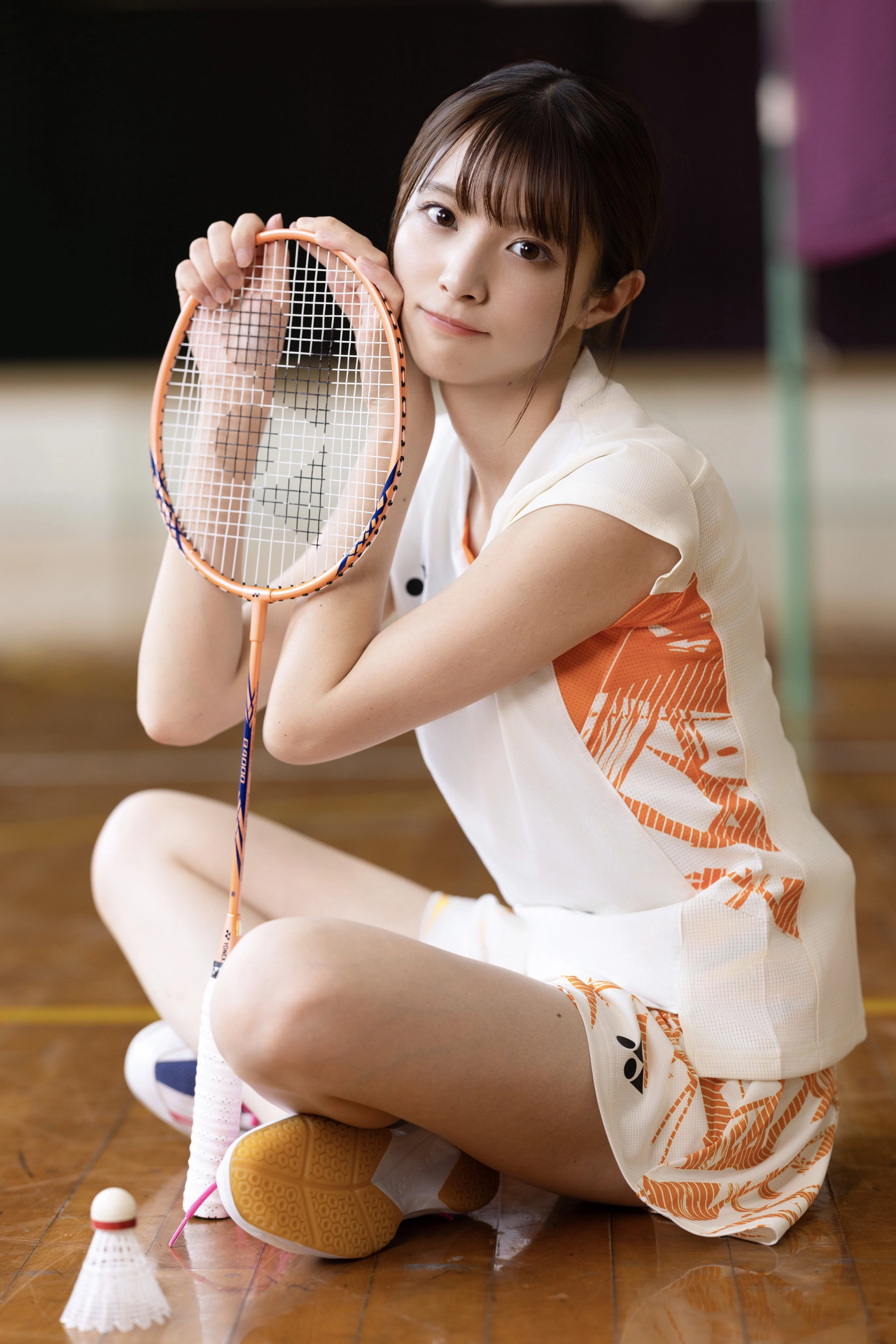 女人拿着一根网球雷克。