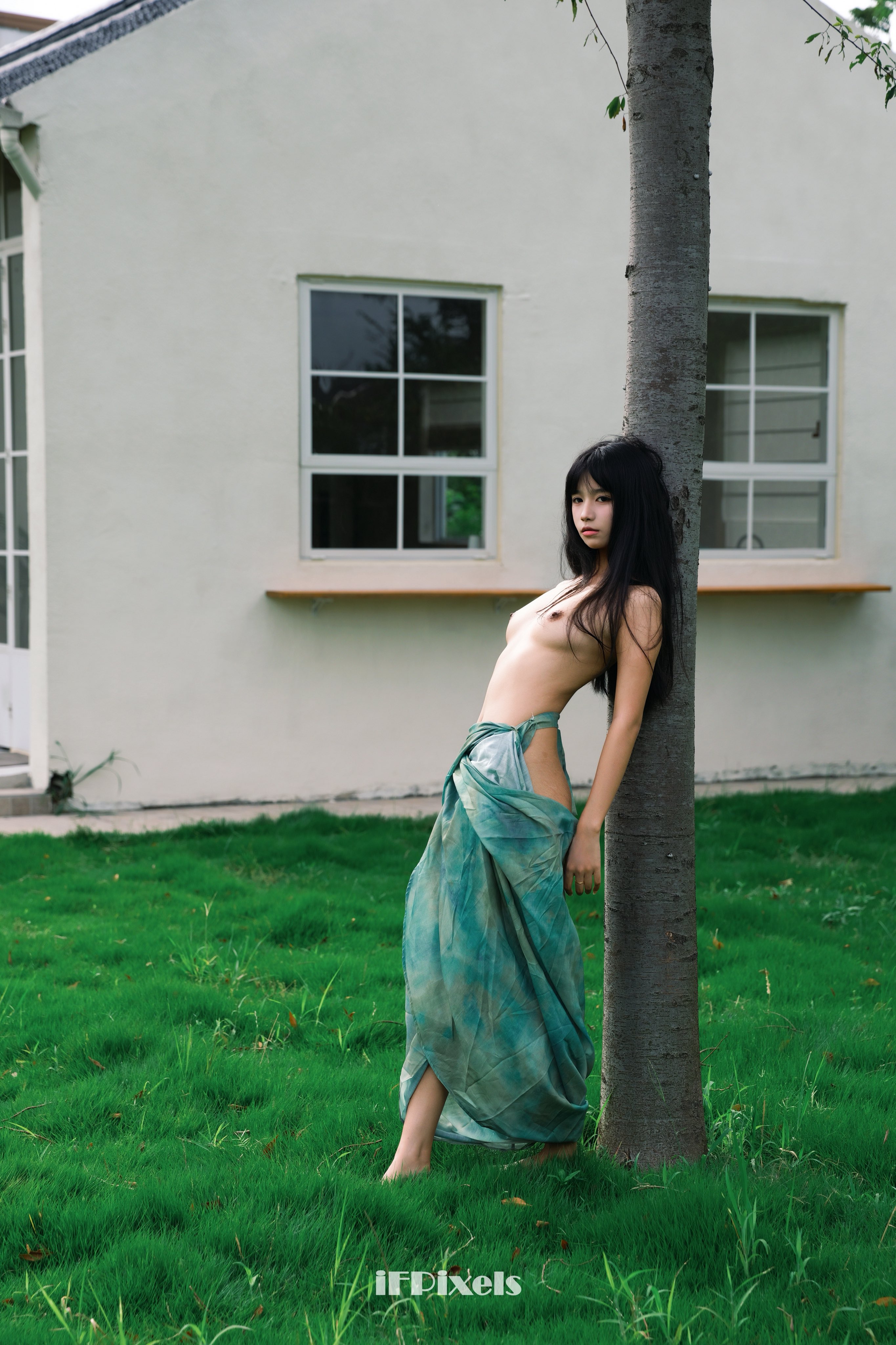 女人站在一棵树前拍一张照片。