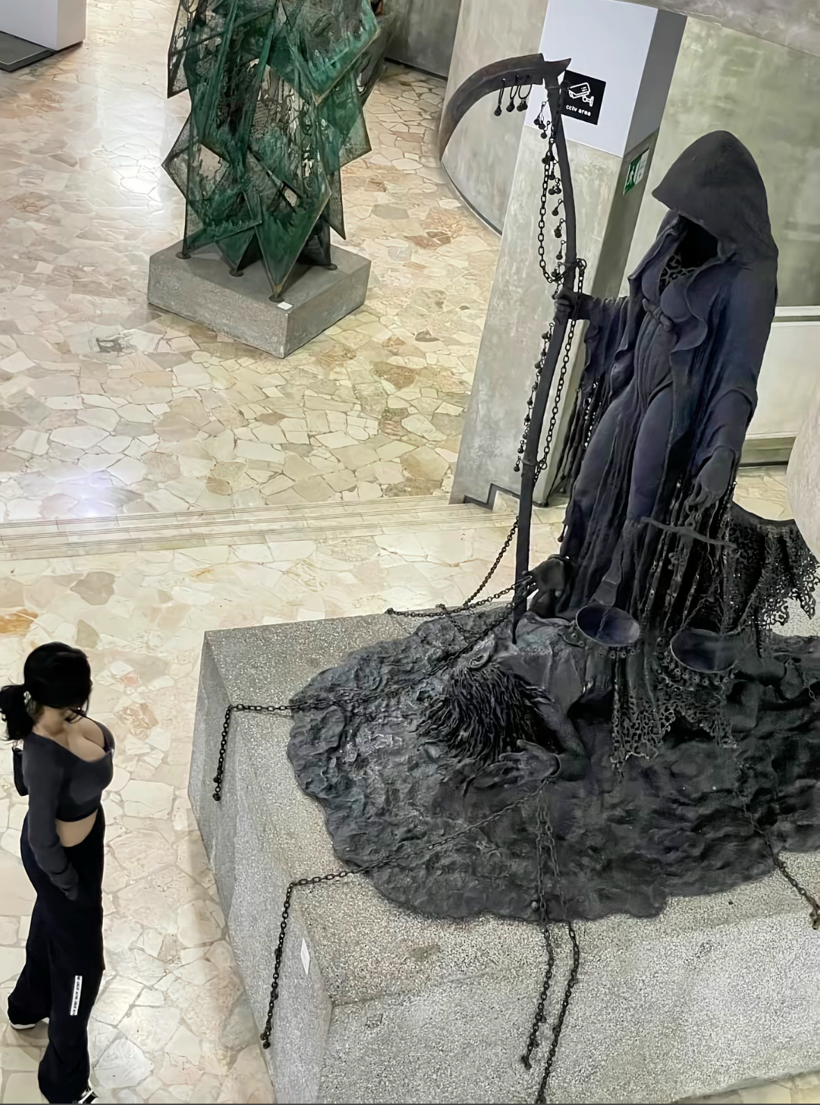 女人站在一个雕像的骨骼,持有一个尺度。