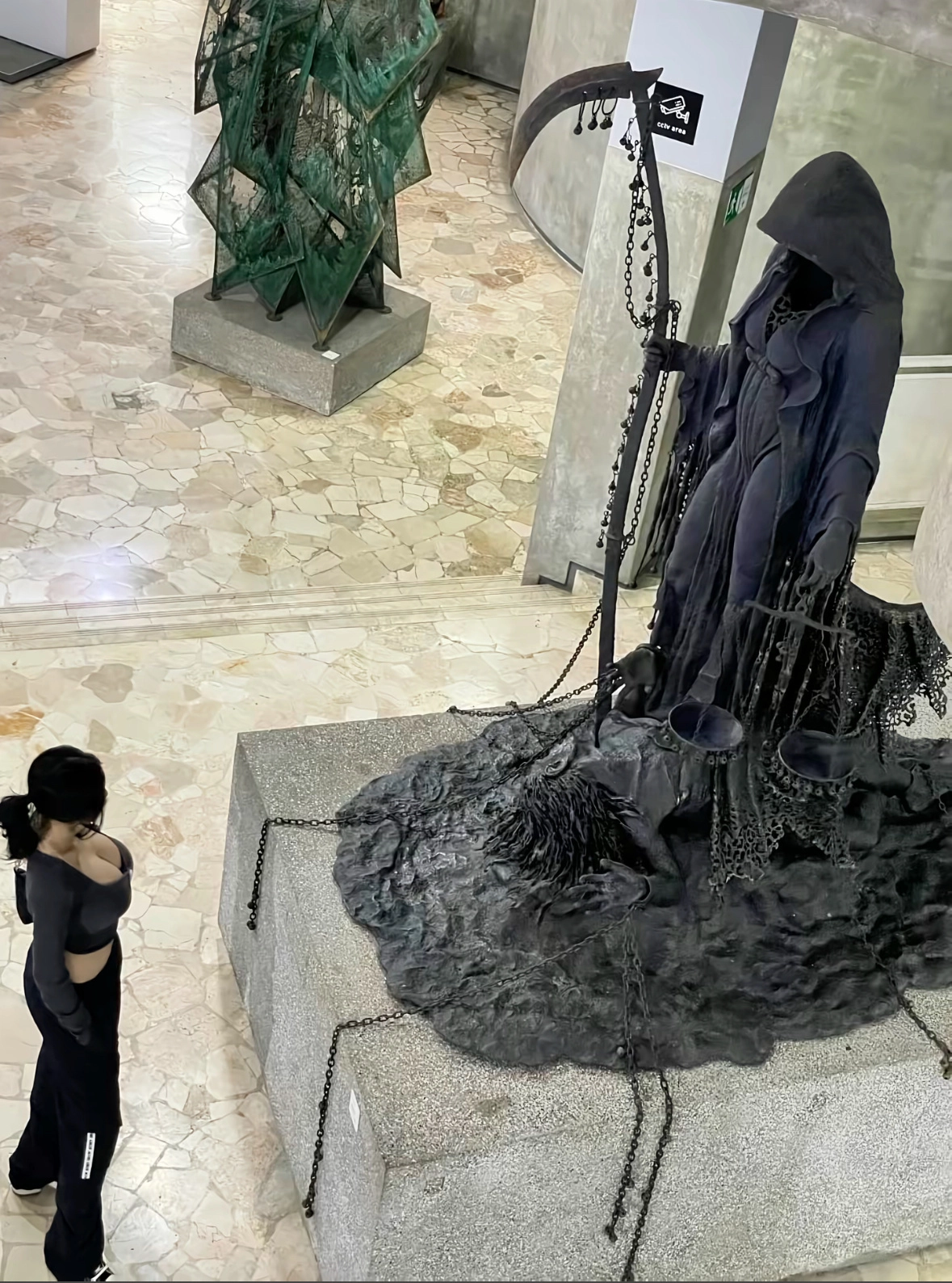 女人站在一个雕像的骨骼,持有一个尺度。