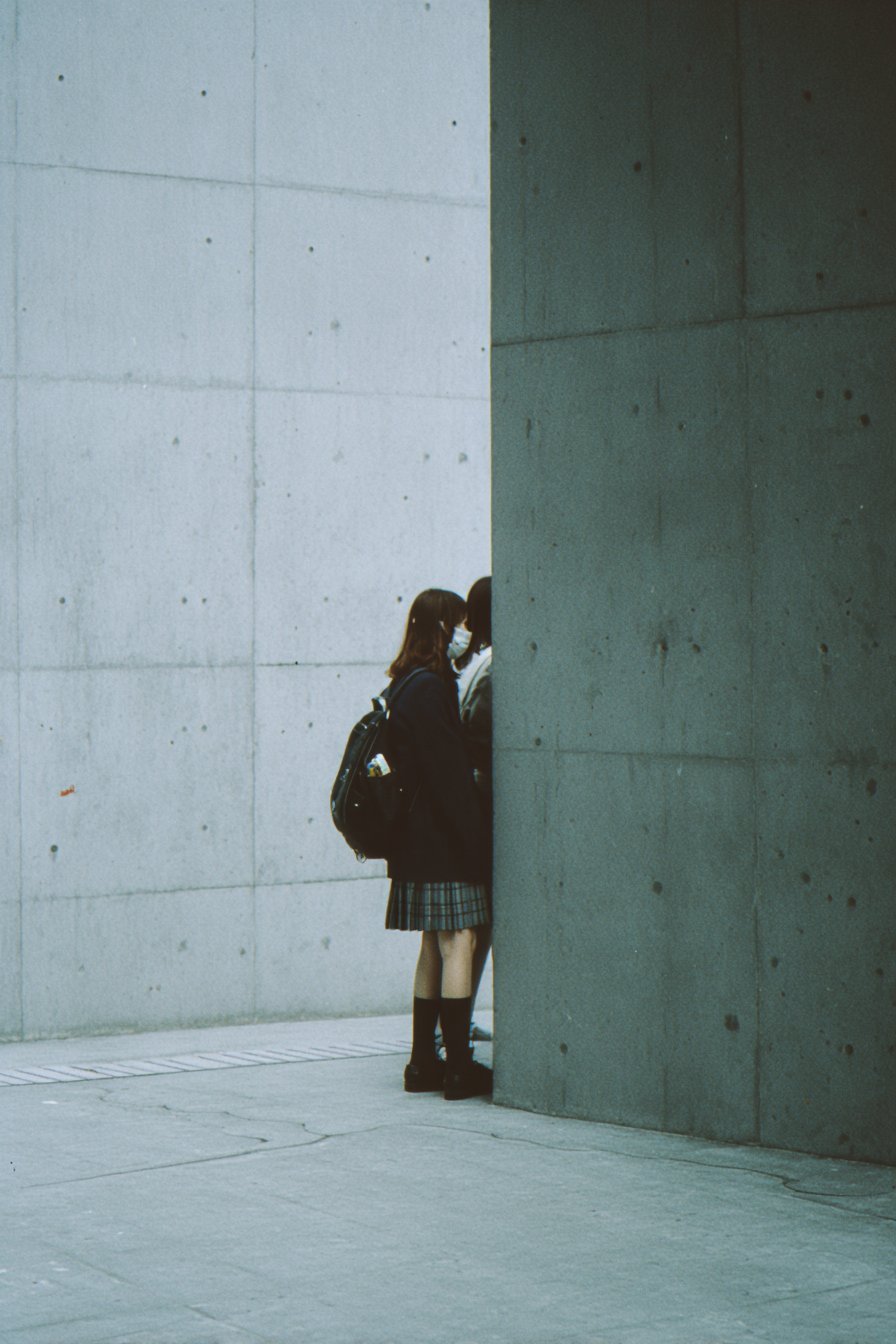 两个人站在一堵墙前。