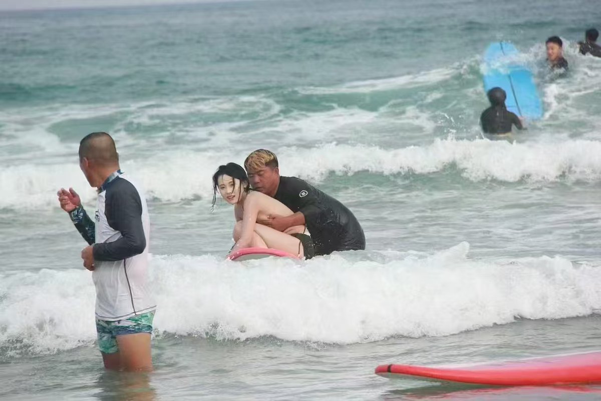 男人和一个女人在海里,一个男人抱着一个女人。