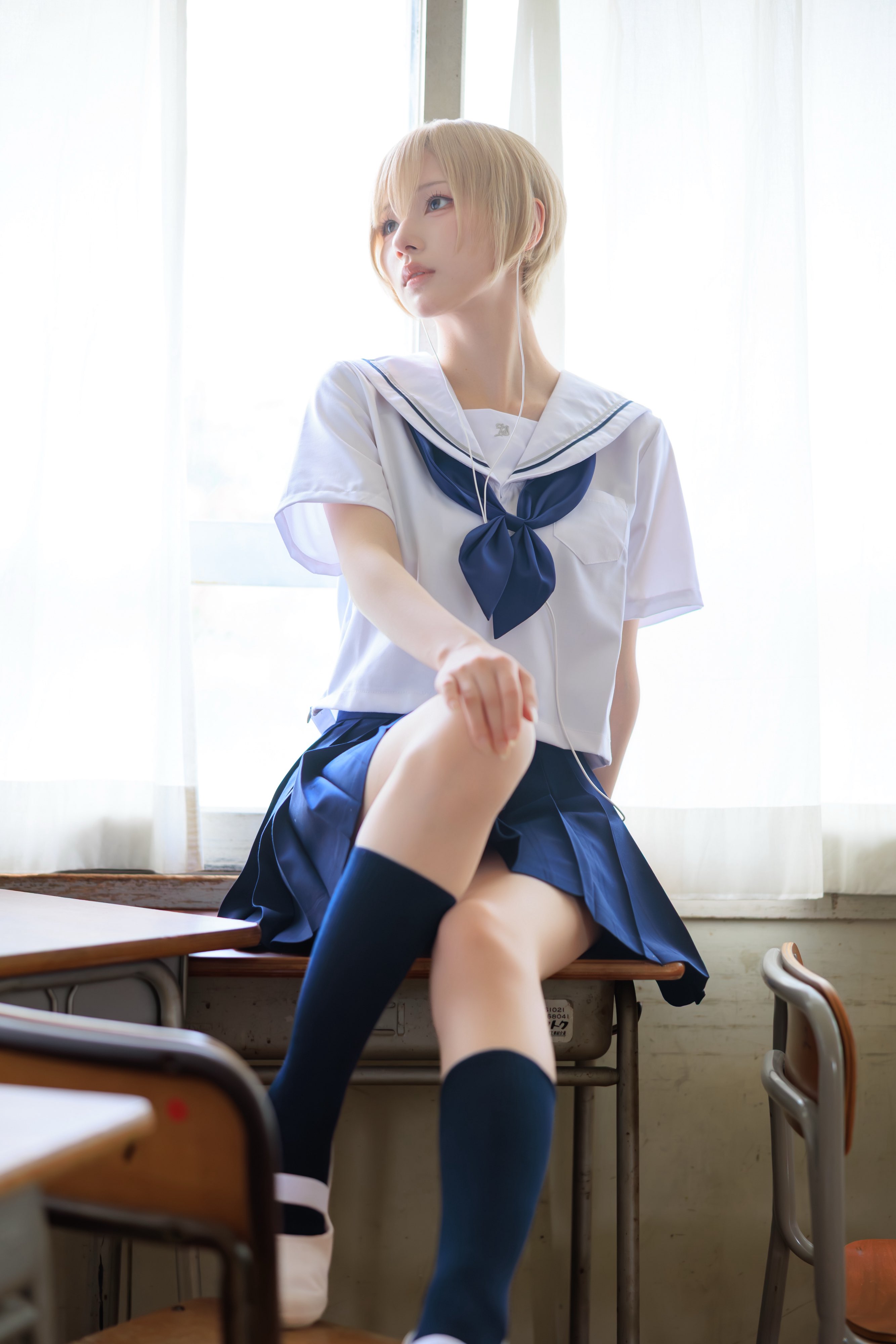 穿着白色衬衫和蓝色衬衫的女人坐在一个凳子上。