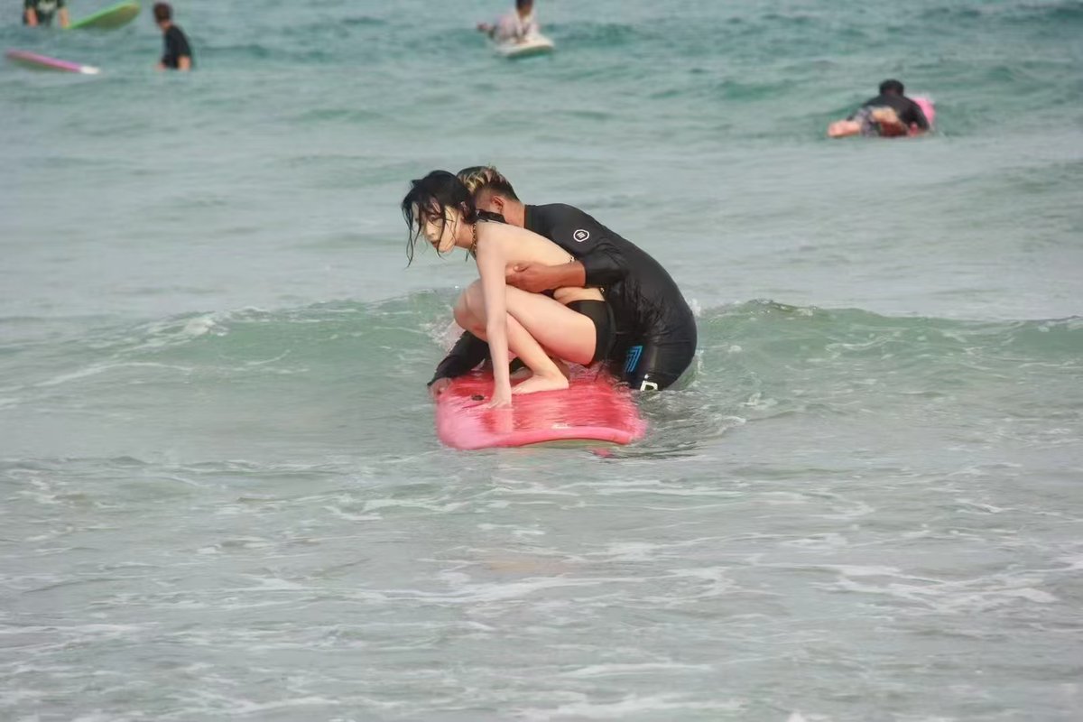 男人和一个女人在海里,一个男人抱着一个女人。