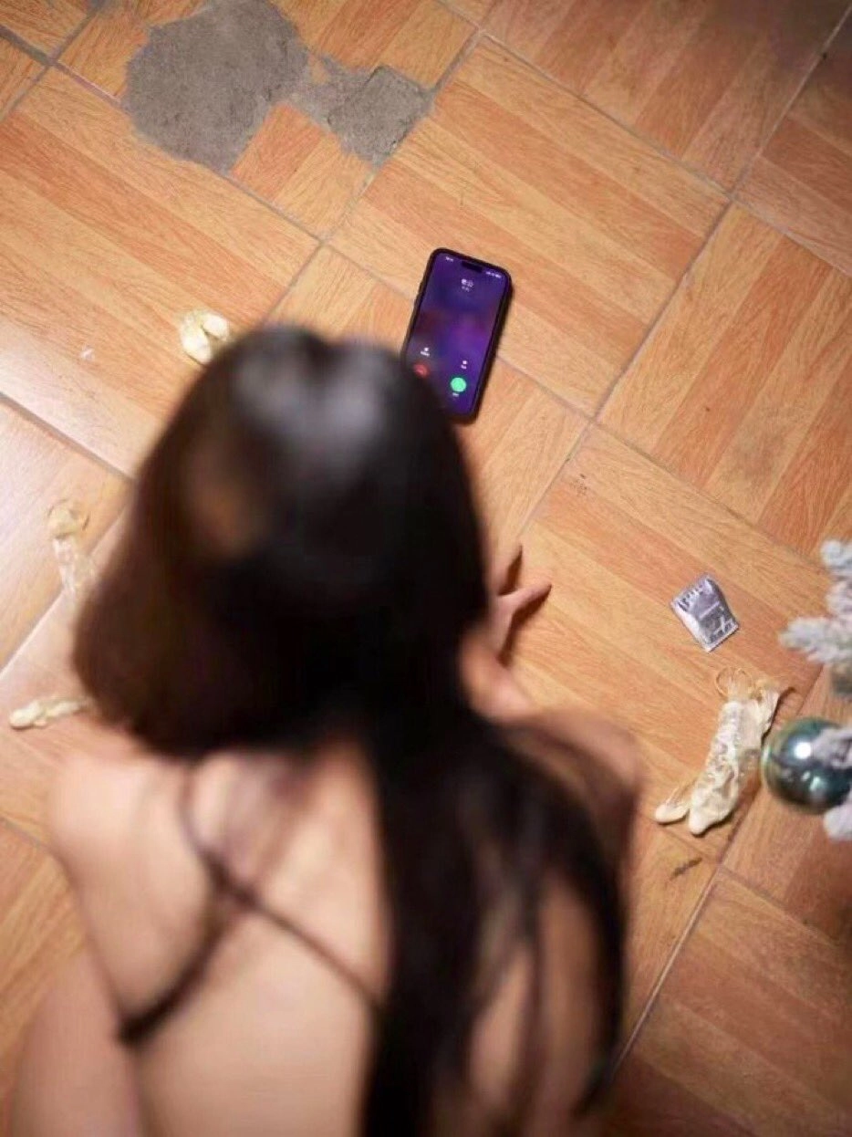 女人坐在地板上看着她的手机。