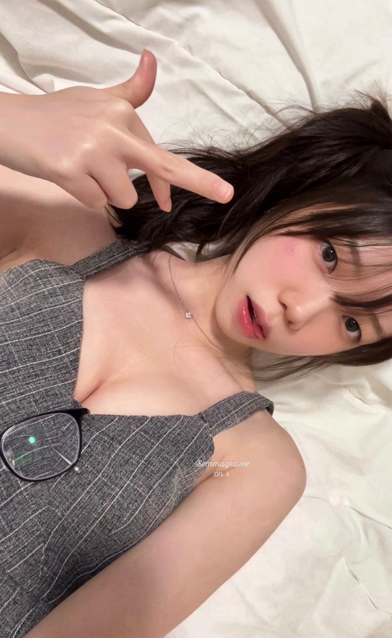 穿着灰色的裙子和眼镜的女人正在制作一个有趣的面孔。