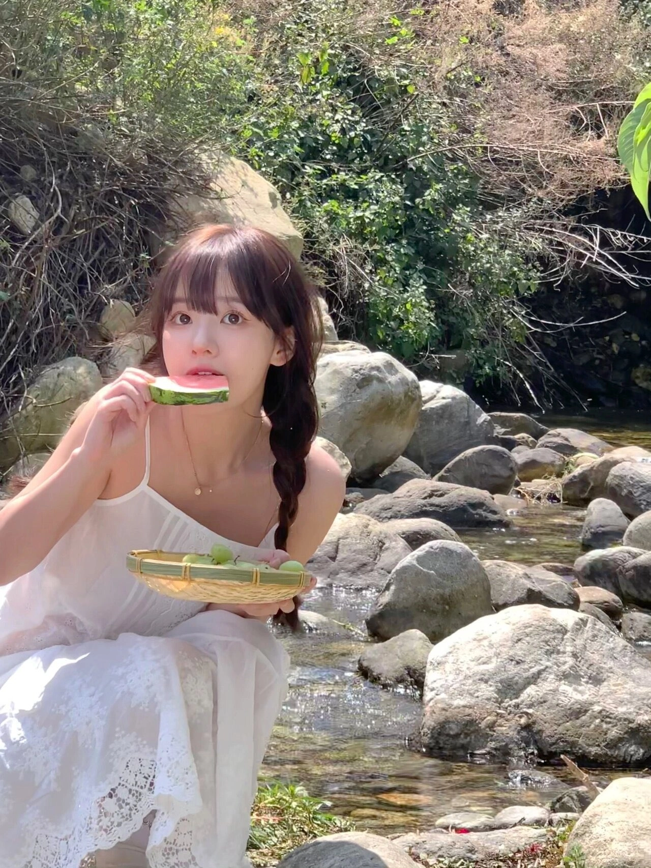 女人在河里吃水。