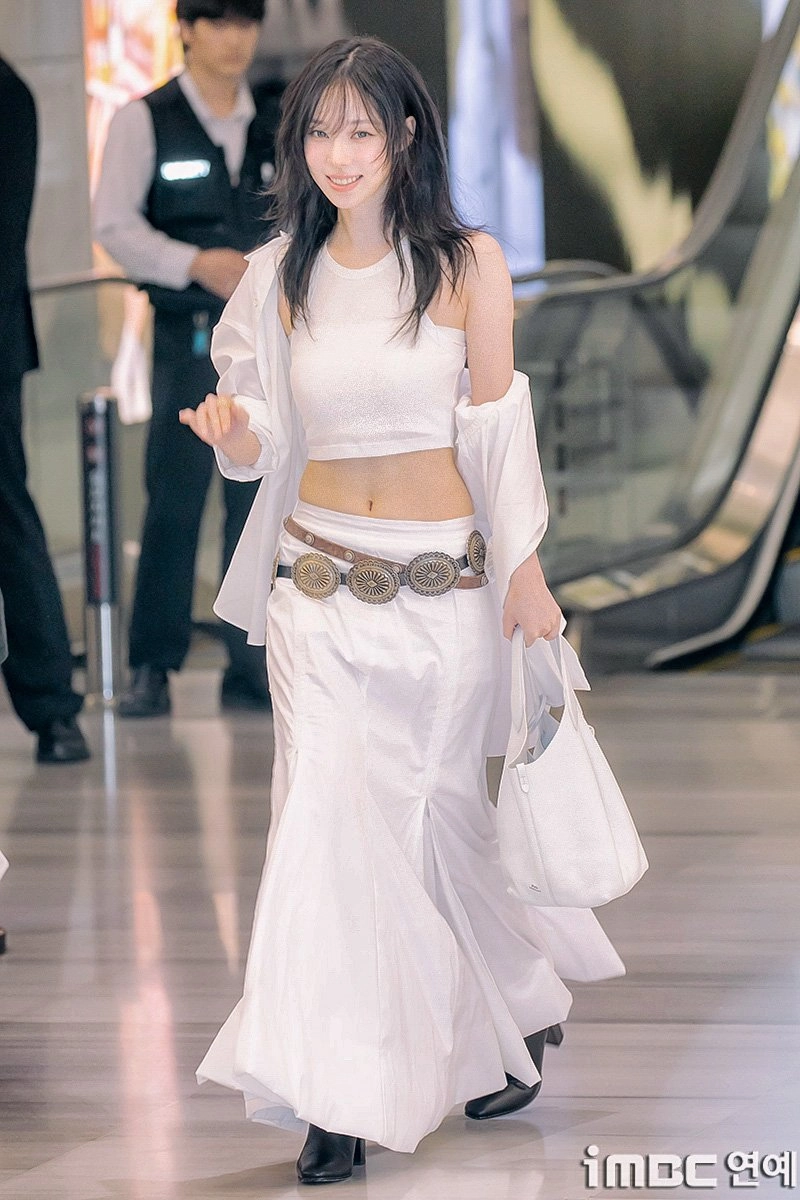 女人穿着白色裙子,带着白色钱包。