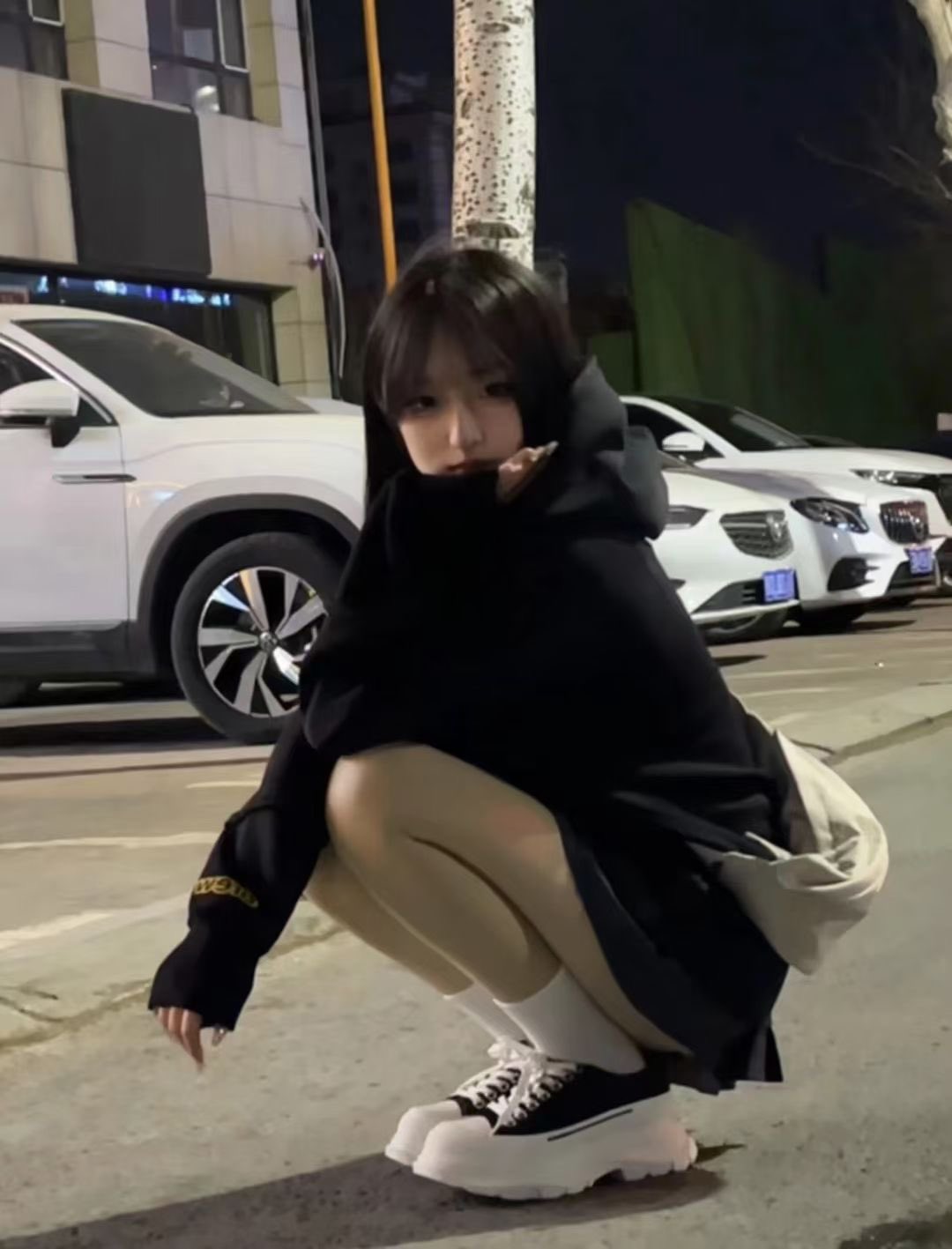 穿着黑色毛衣的女人跪在地上。