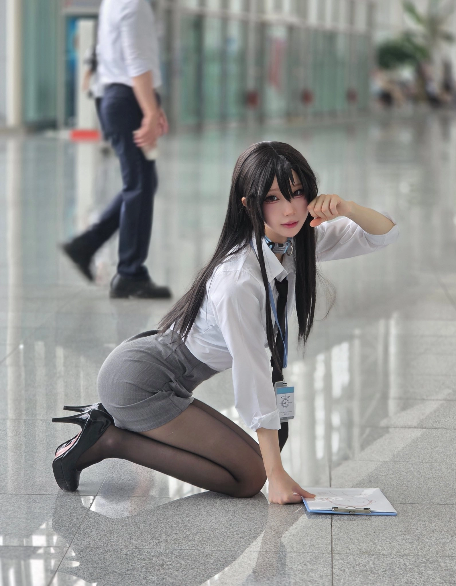 穿着白色衬衫和黑色裙子的女人跪在地板上。