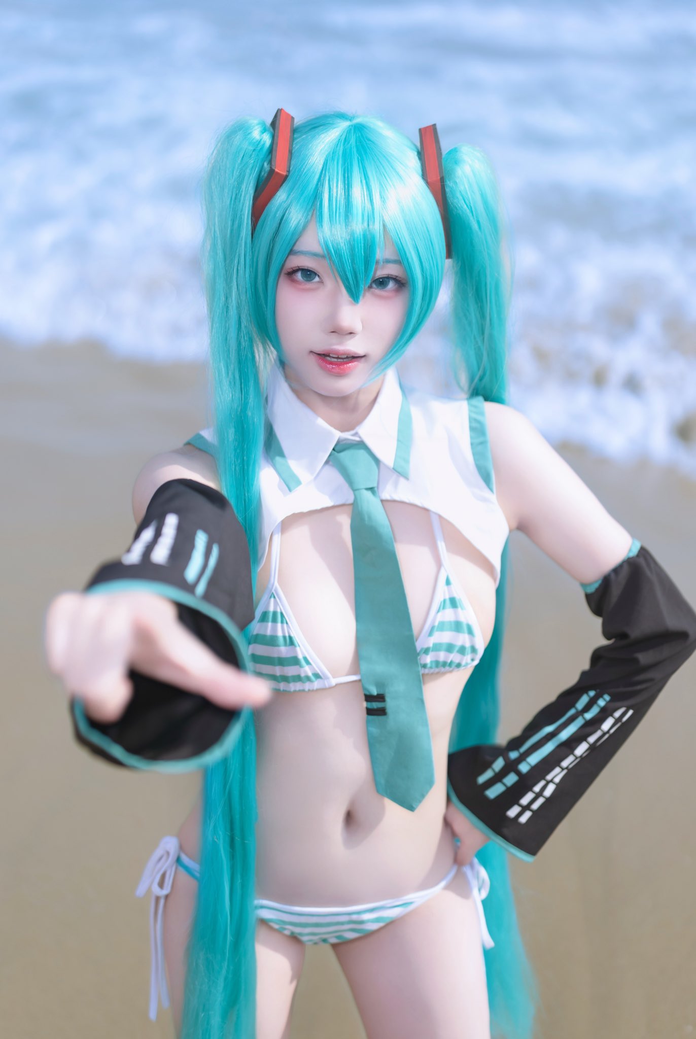 穿着蓝色和白色衣服的女人站在海滩上。