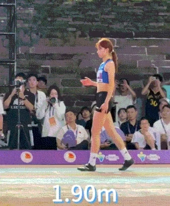 一位穿着蓝色衬衫和黑色短裤的女人在院子上行走。