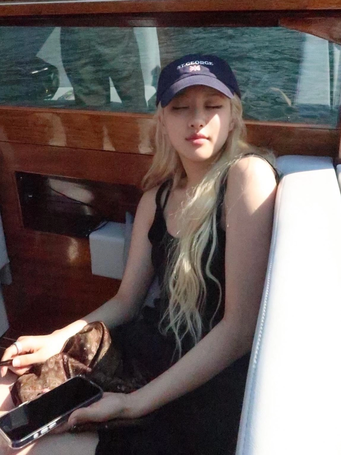 一位穿着一顶帽子和一件黑色衬衫的女人坐在船上。