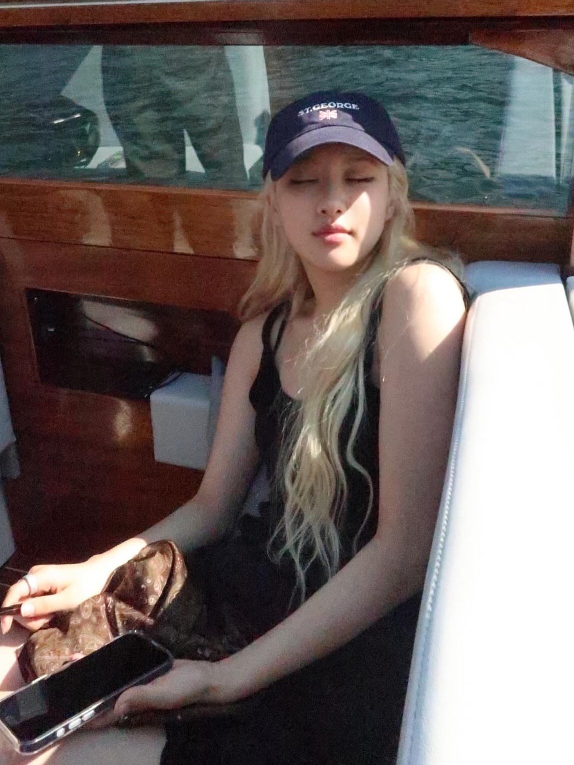 一位穿着一顶帽子和一件黑色衬衫的女人坐在船上。