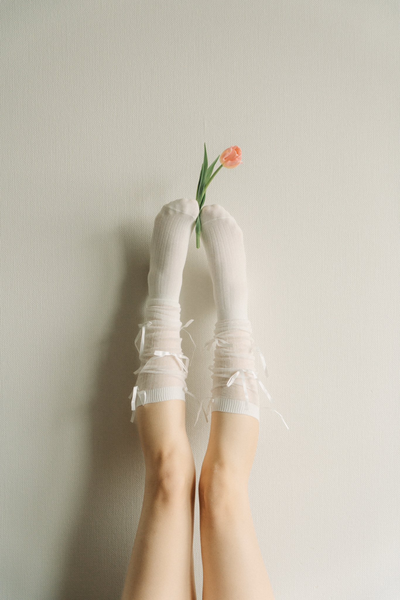 女人穿着白色袜子,拿着一朵花。