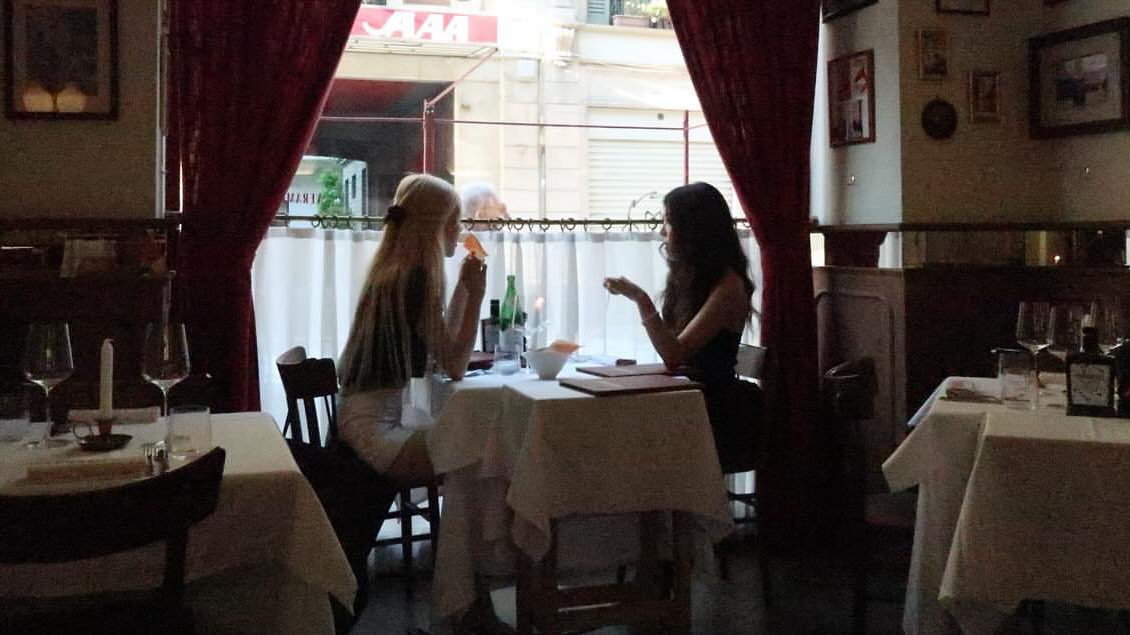 两个女人在客厅里,一个坐在沙发上,另一个站着。