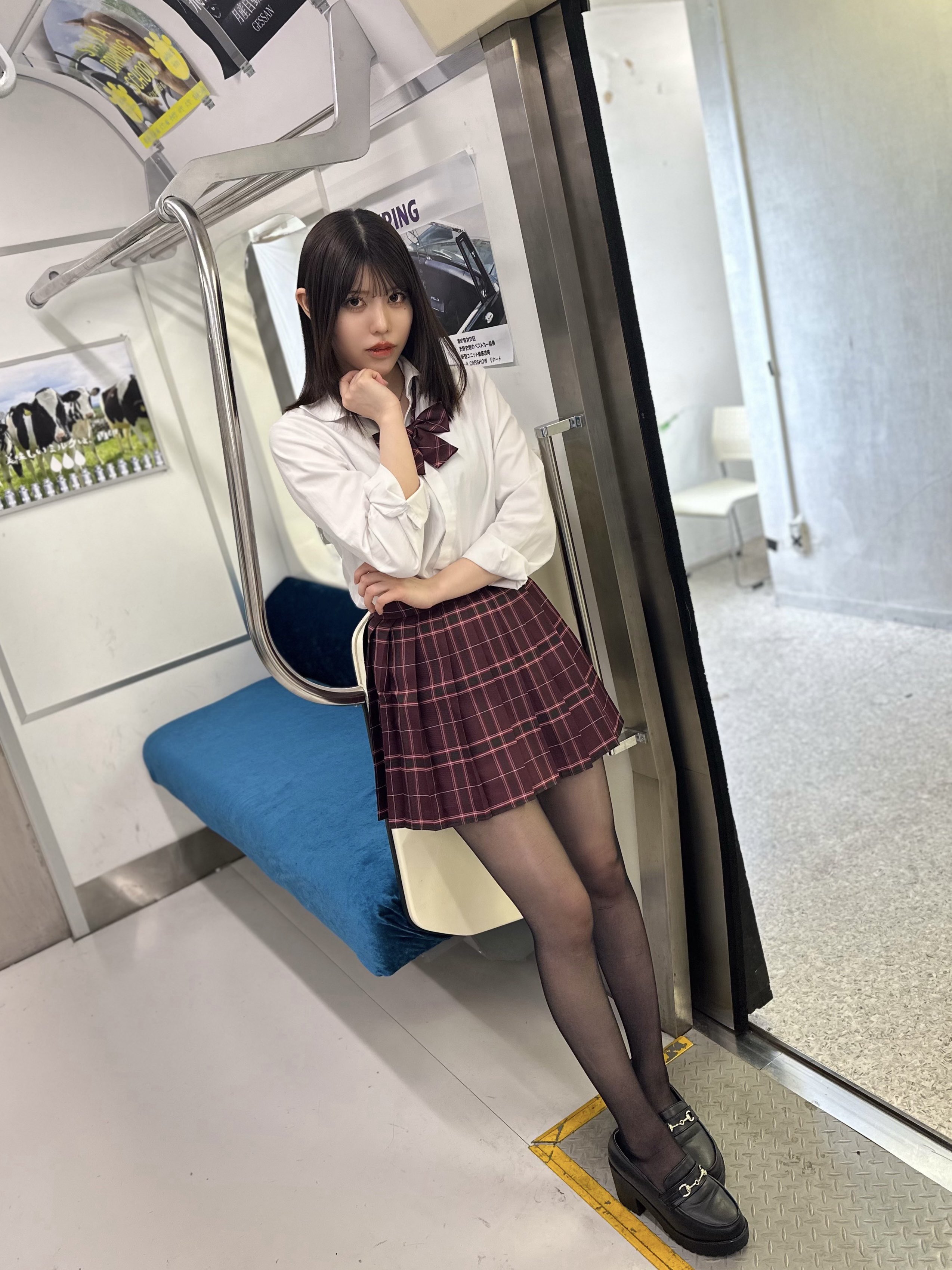 一位穿着白色衬衫和一件白色裙子的女人站在一辆地铁车上。