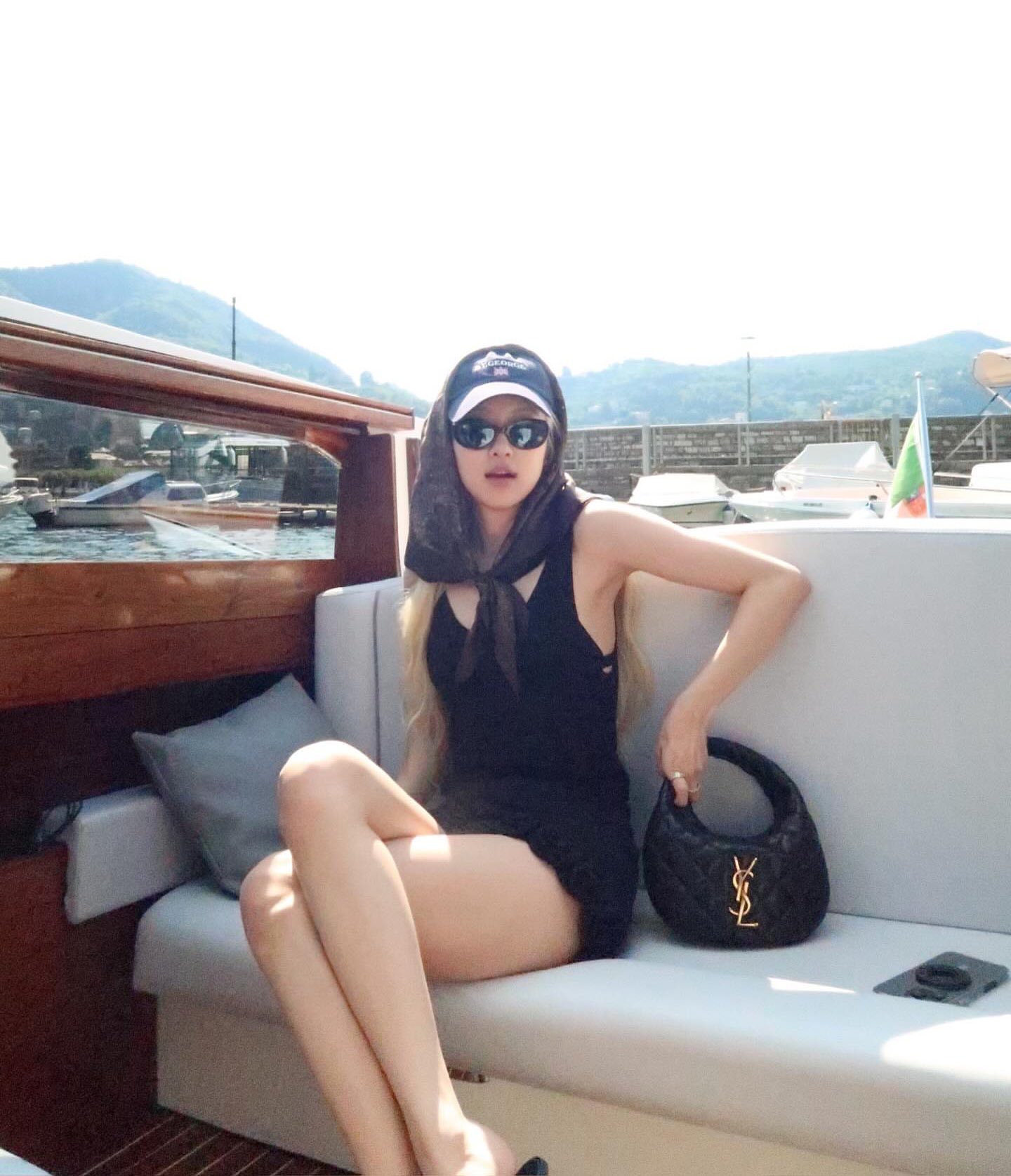 一位穿着一顶帽子和一件黑色衬衫的女人坐在船上。