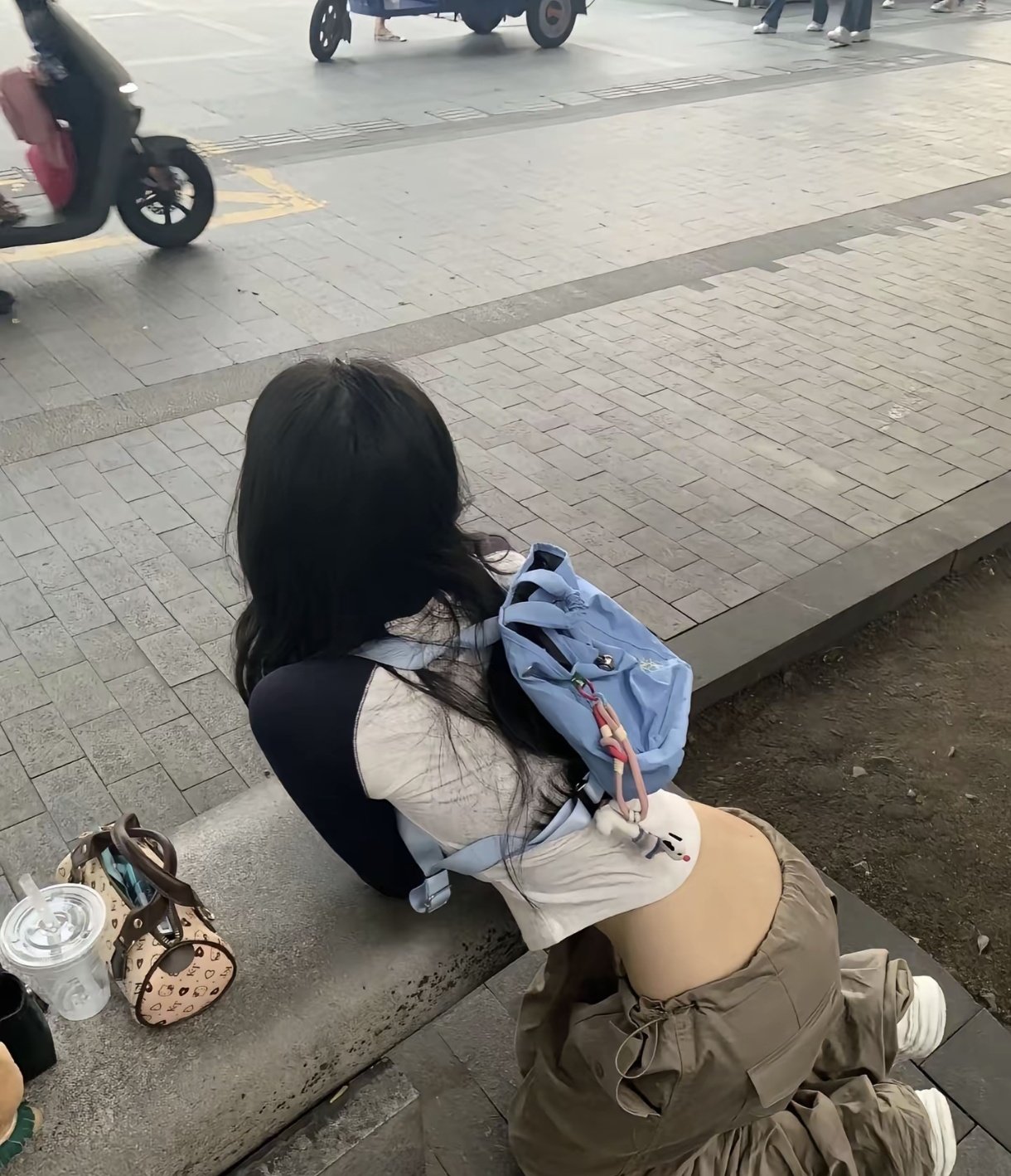 带着蓝背包的女人坐在一边。