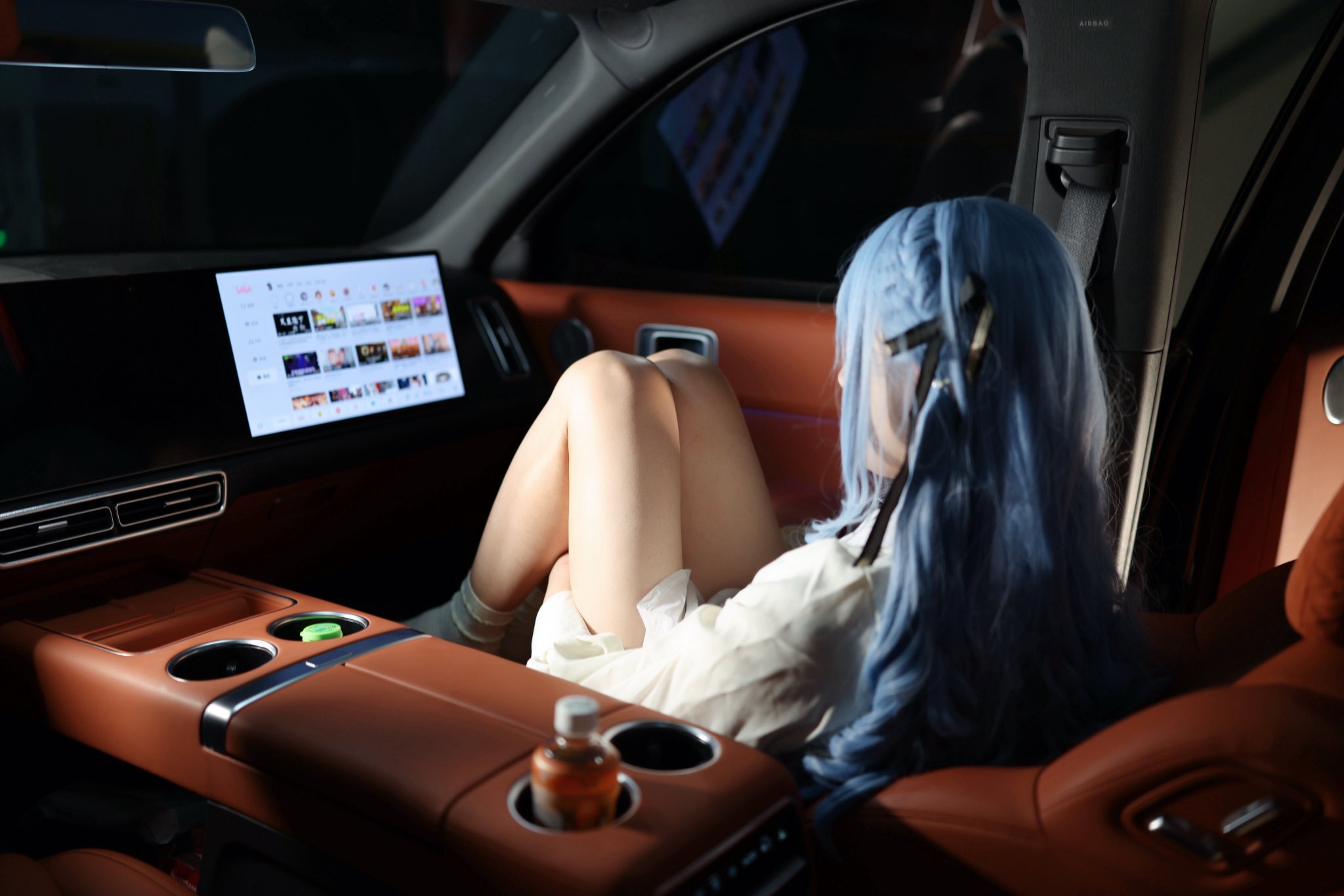 女人在车里,蓝头发和一件白色衬衫。