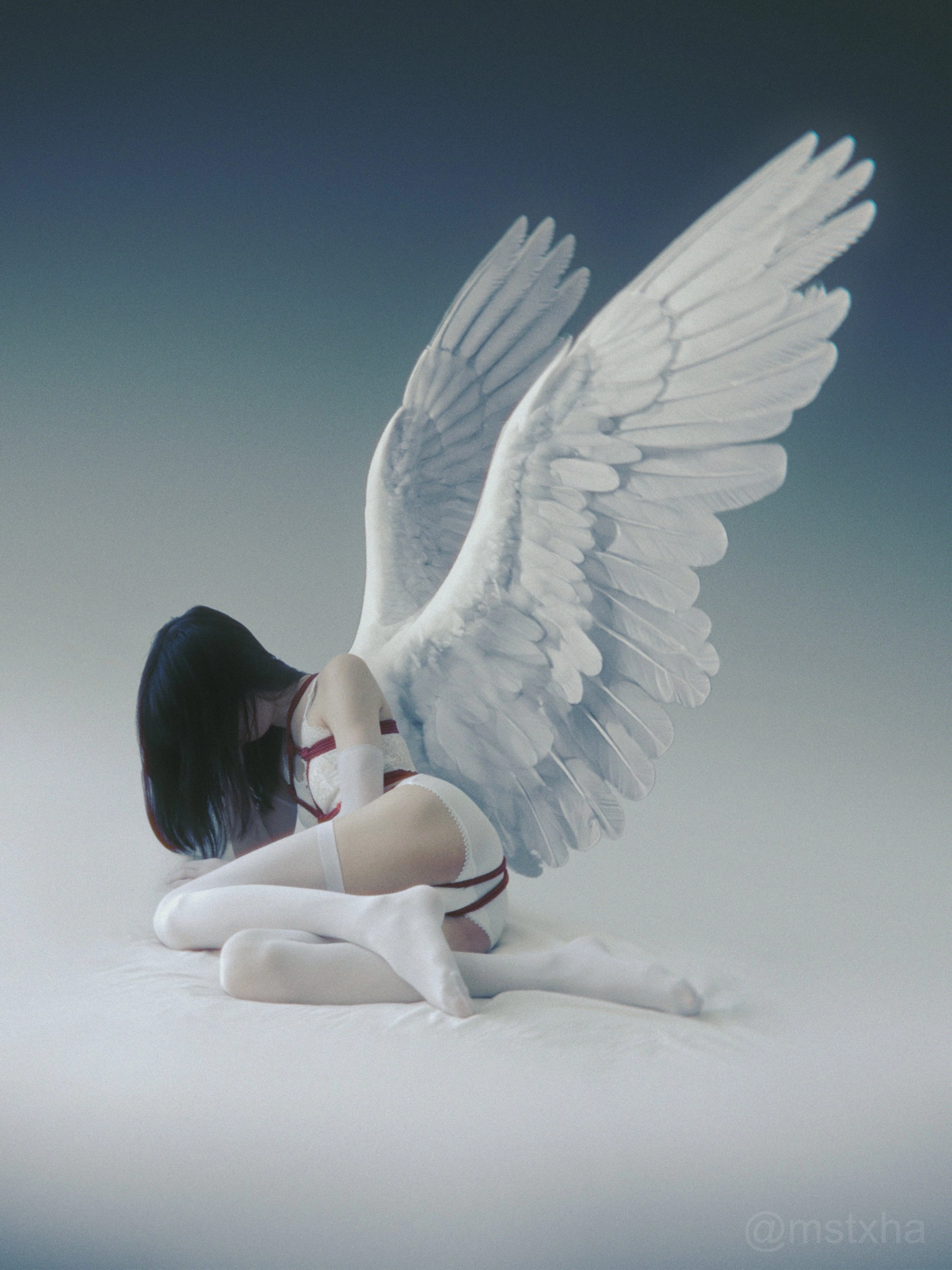 有翅膀的女人坐在床上。