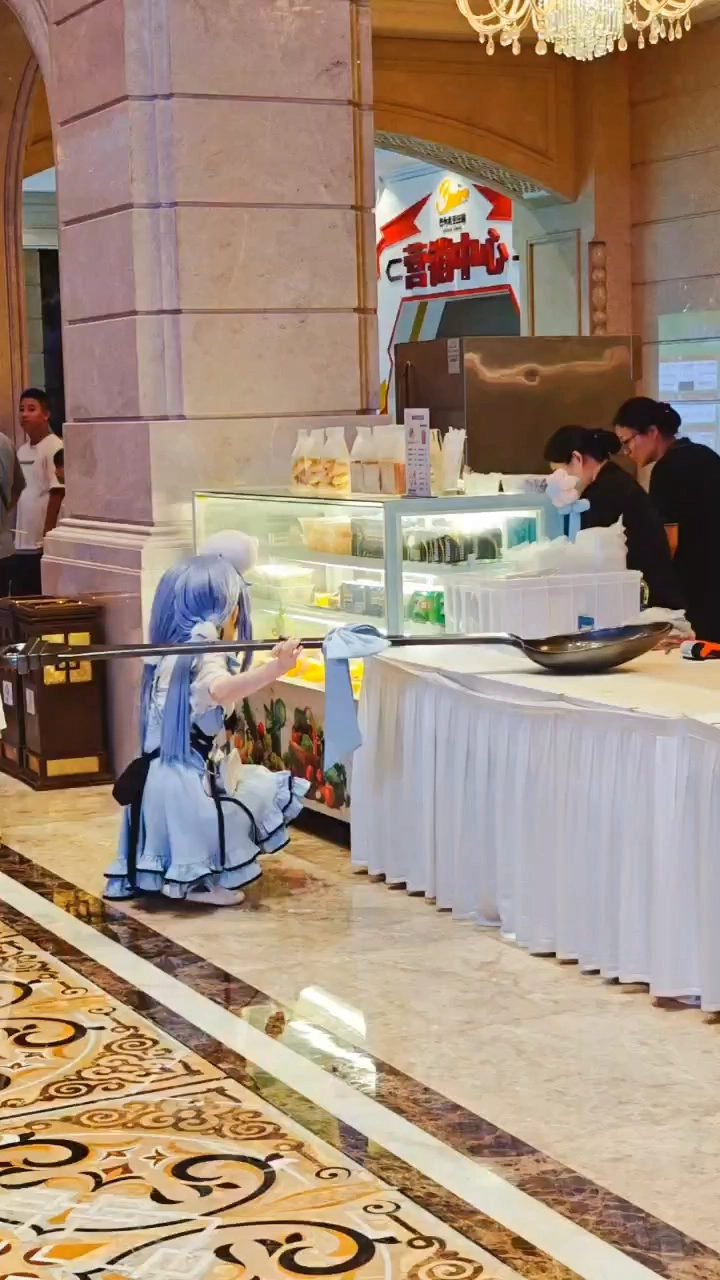 穿着蓝色衣服的女人在冰箱前跪下。